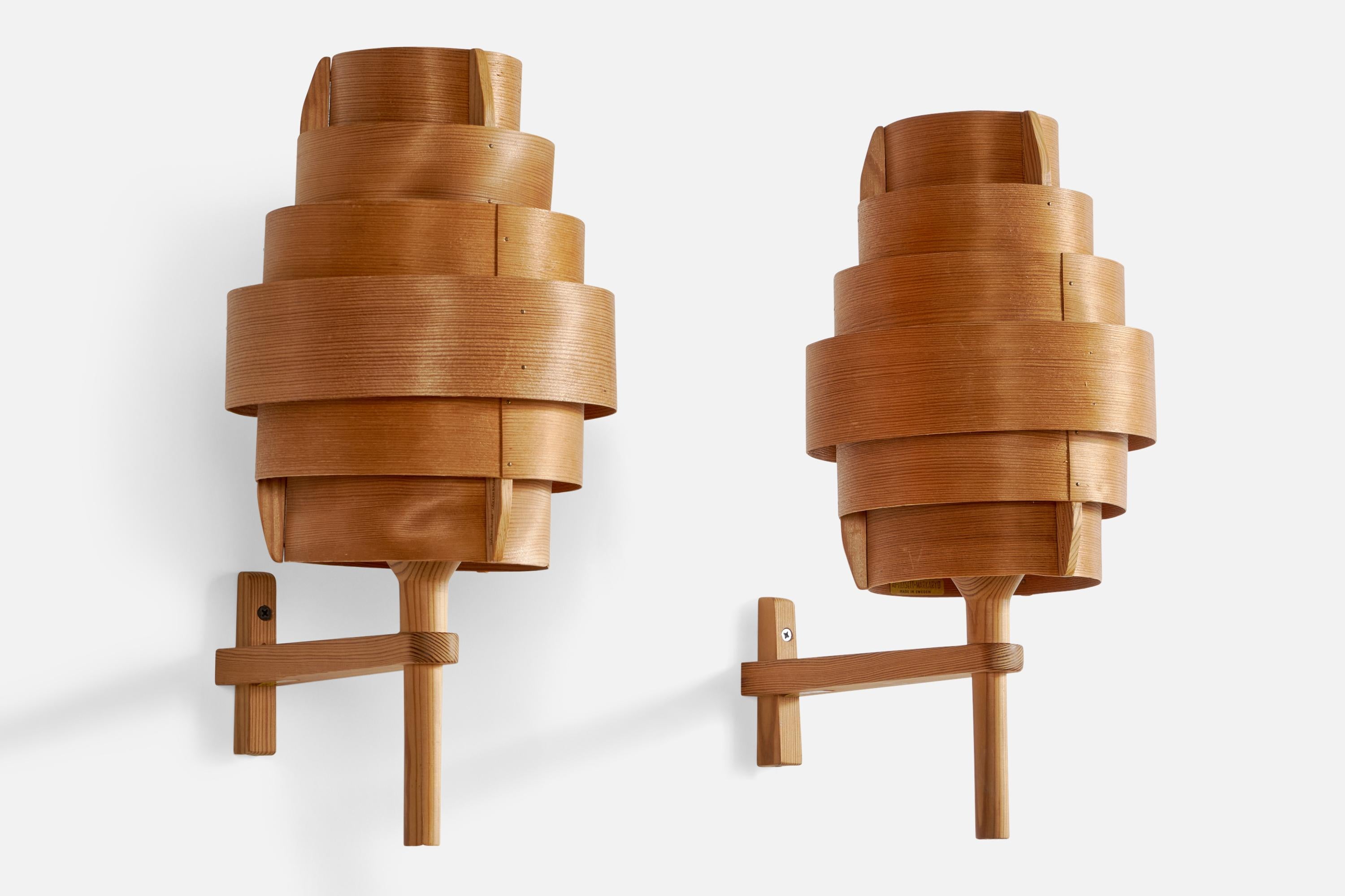A pair of pine and moulded pine veneer wall lights designed and produced by Hans-Agne Jakobsson, Sweden, 1970s.

Overall Dimensions (inches): 15.8” H x 7.5” W x 11.75” D
Back Plate Dimensions (inches): 4” H x 1.65” W x 0.9” D
Bulb Specifications: