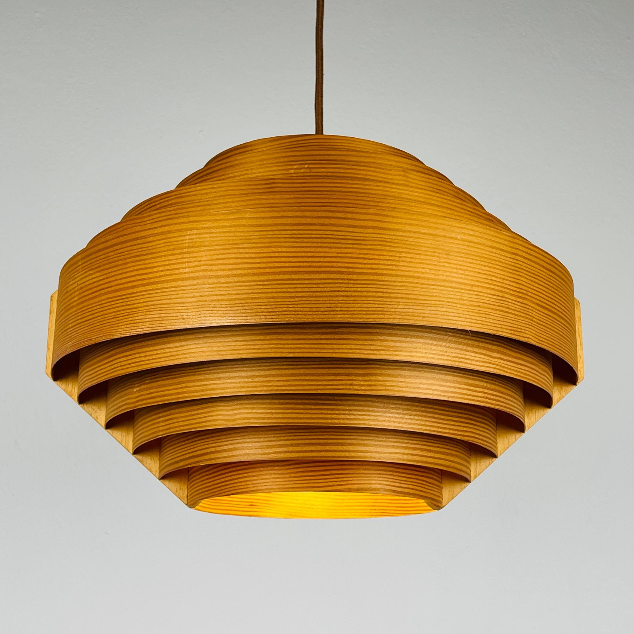 Transport your space to the 1960s with this exquisite wooden pendant lamp by Hans-Agne Jakobsson, crafted for AB Ellysett in Markaryd, Sweden. Hans-Agne Jakobsson, renowned for his pine veneer lamps, meticulously crafted thin strips of pine wood