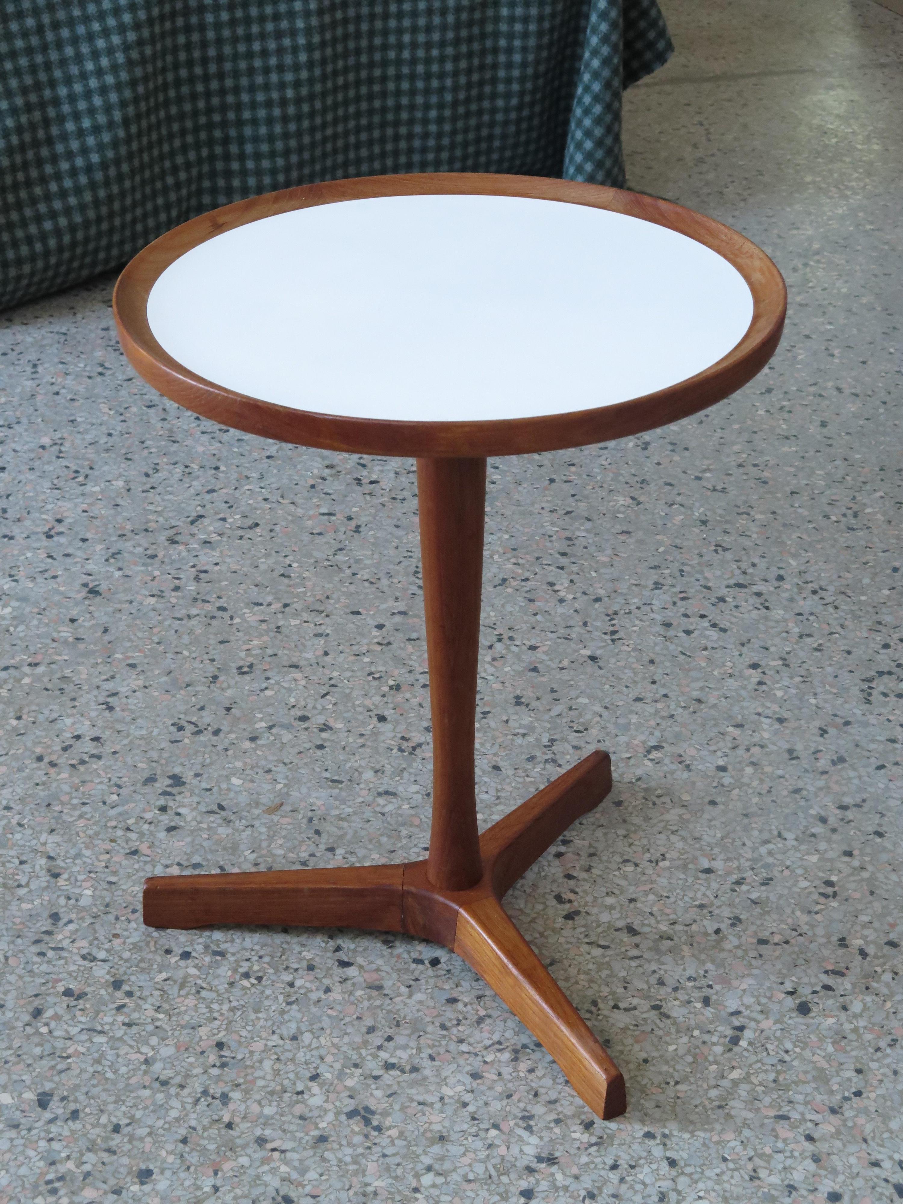 A classic Danish side table with three legs by Hans Andersen. Round top in white mica, teak wood. Nice patina and very good / excellent original condition.