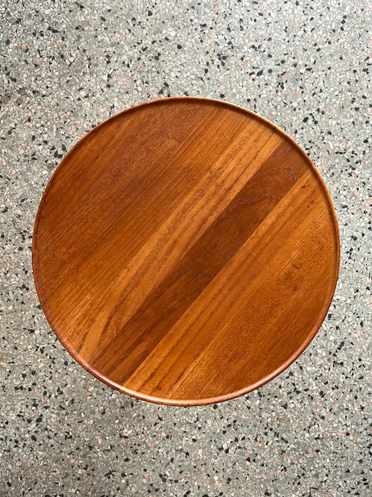 A classic Danish side table with three legs by Hans Andersen. Round top in original  teak wood. Nice patina and very good condition. Signed underneath.