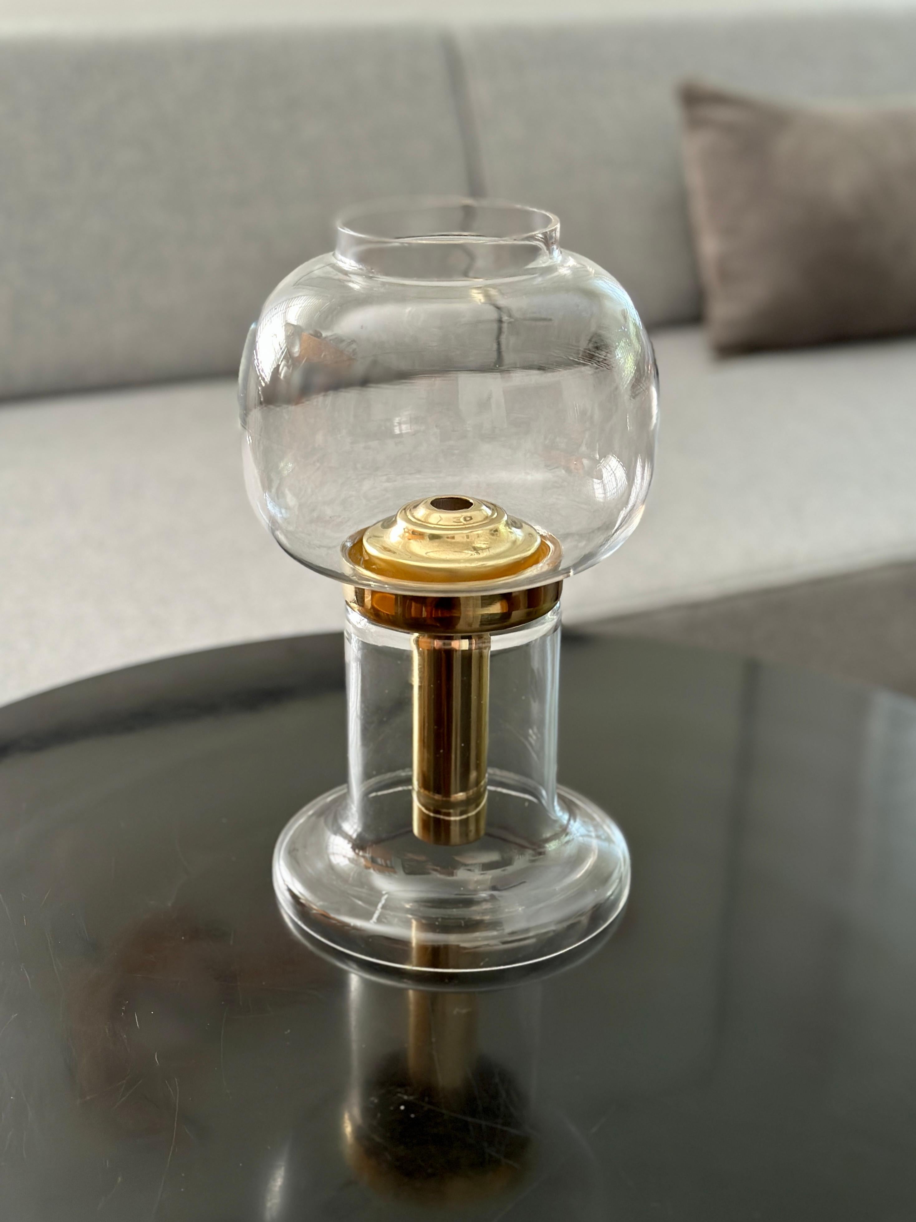 DESCRIPTION

A lamp / lantern designed by Hans-Agne Jakobsson and produced by his own company, Hans-Agne Jakobsson AB sometime in the 1970’s. The candlestick mechanism is solid brass with a glass base and globe. The brass mechanism uses a spring to