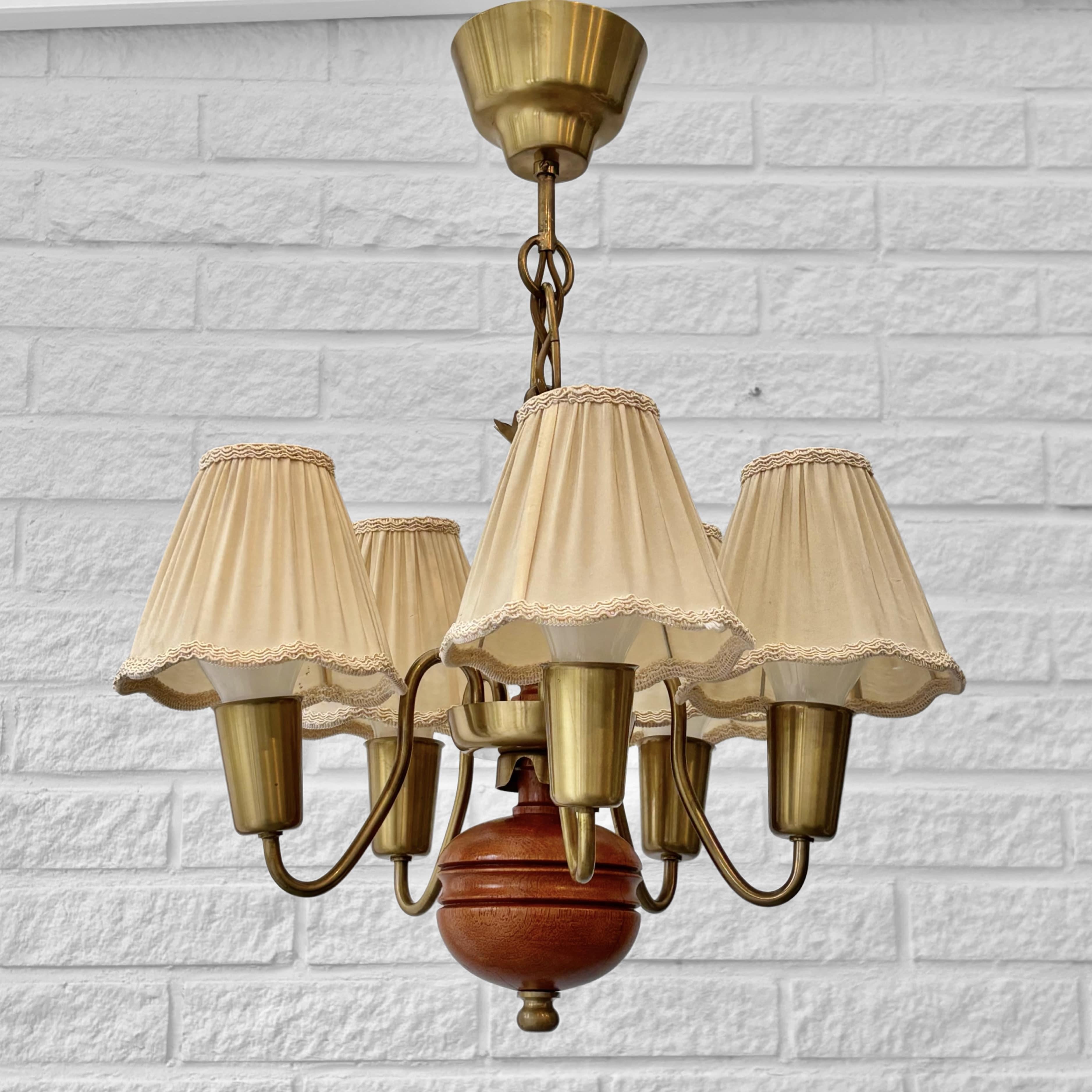 Un magnifique lustre, modèle 115, conçu par le célèbre architecte d'éclairage suédois Hans Bergström et produit par Ateljé Lyktan dans les années 1940. Fabriqué à partir d'un cadre en bois teinté supportant cinq bras courbés en laiton, il présente