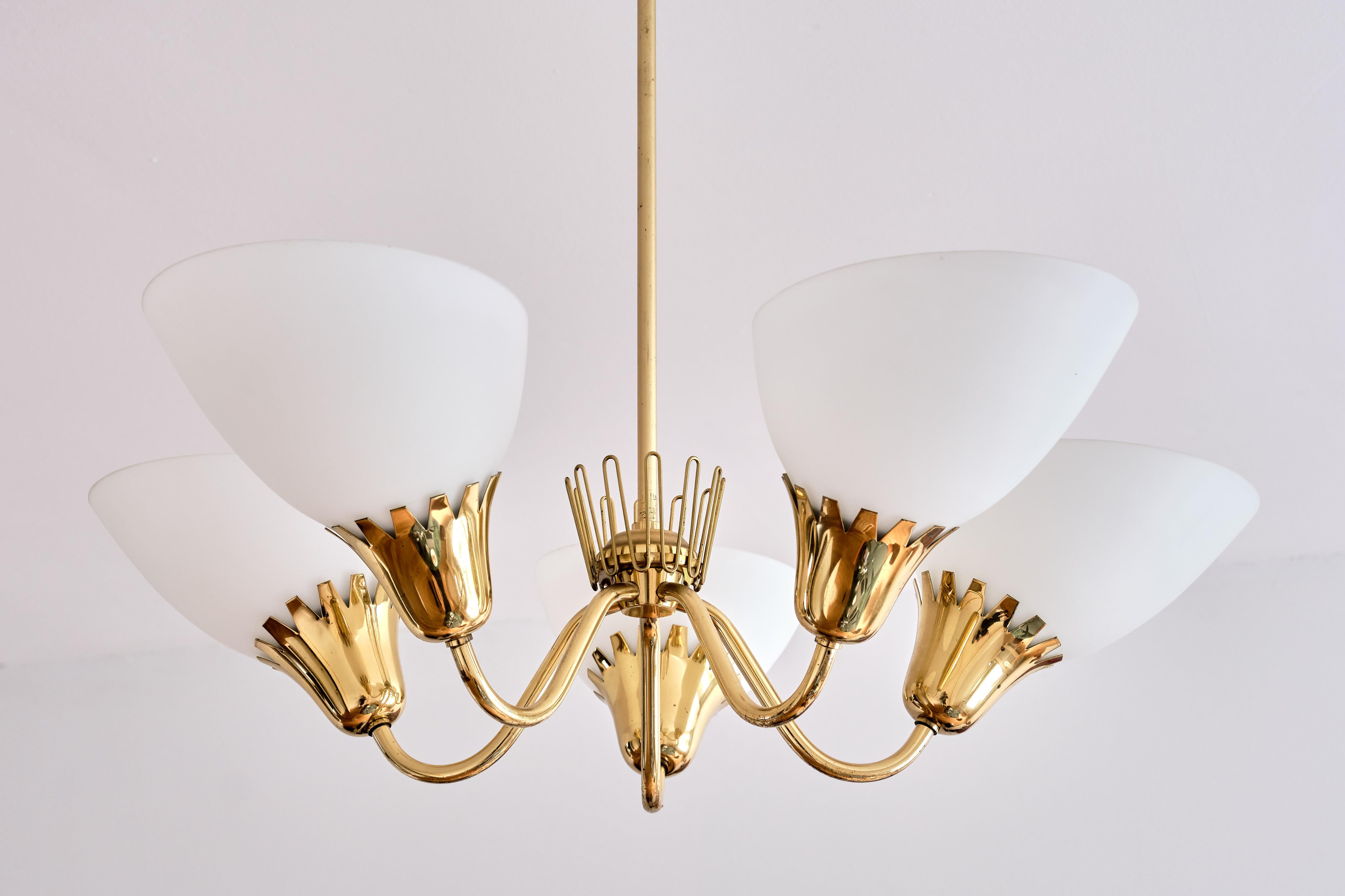 This rare five arm chandelier was produced by ASEA in Sweden in the early 1950s. Brass stem, five arms and fittings with matte opaline glass shades. The zigzag edges of the fittings and the decorative brass crown detail in the middle are
