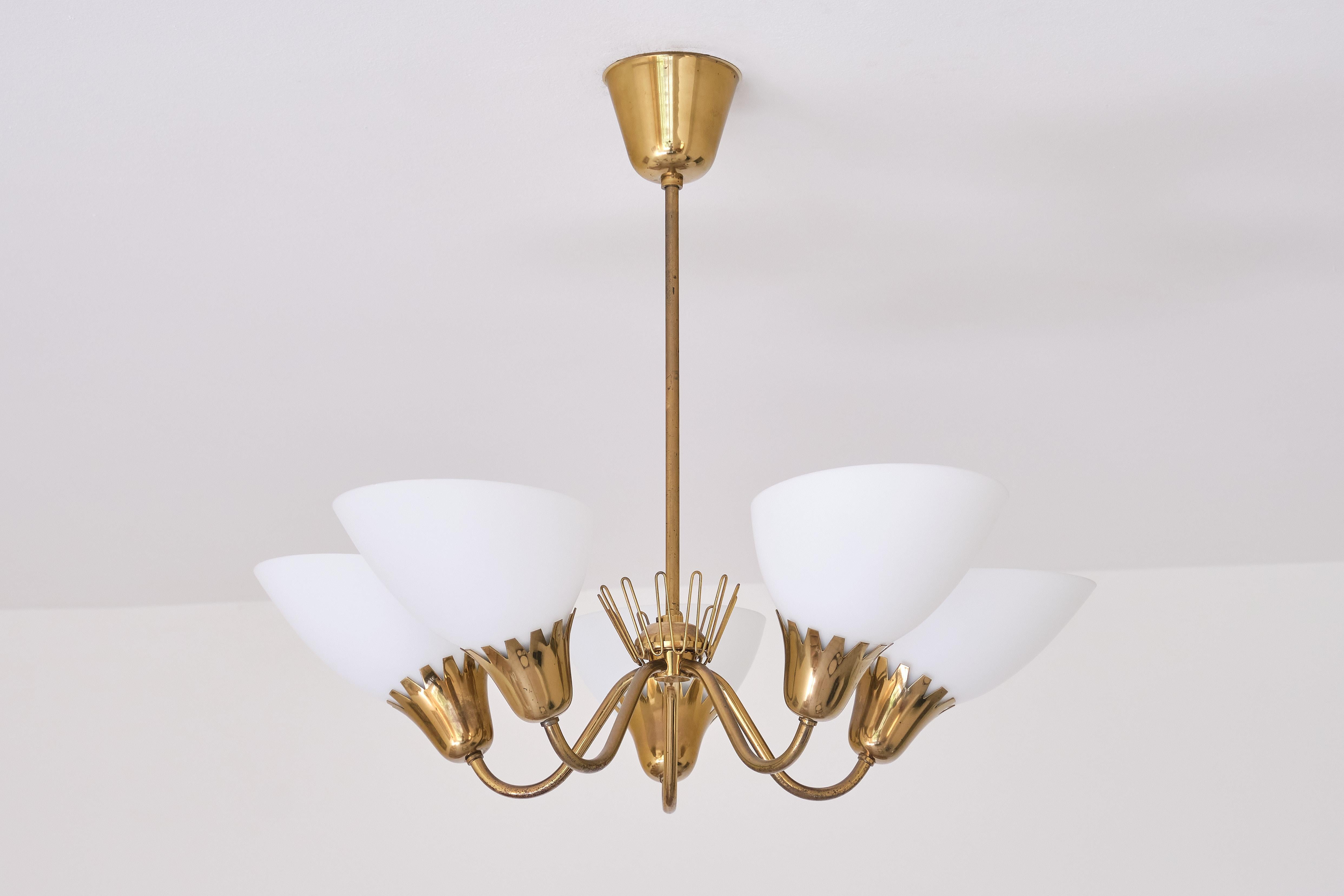 This rare five arm chandelier was produced by ASEA in Sweden in the early 1950s. The lamp consists of a brass stem, five arms and fittings with matte opaline glass shades. The zigzag edges of the fittings and the decorative brass crown detail in the