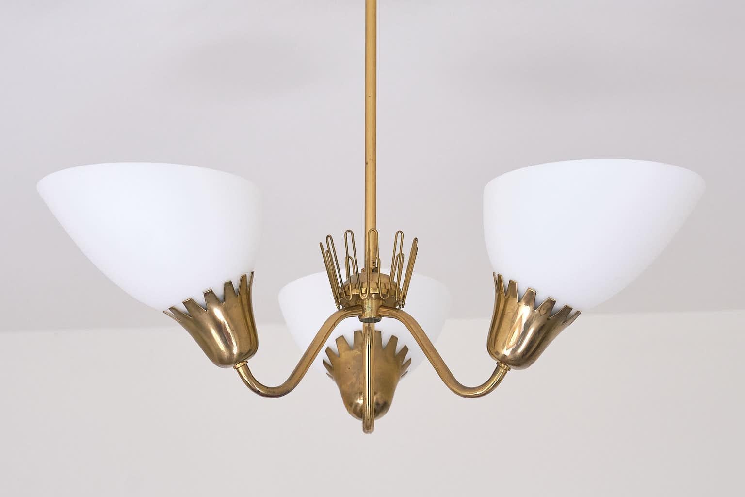 This rare three-arm chandelier was produced by ASEA in Sweden in the early 1950s. The design is attributed to Hans Bergström.

It features a tubular brass stem, three curved arms, and brass fittings adorned with a zigzag cutout trim. The three matte