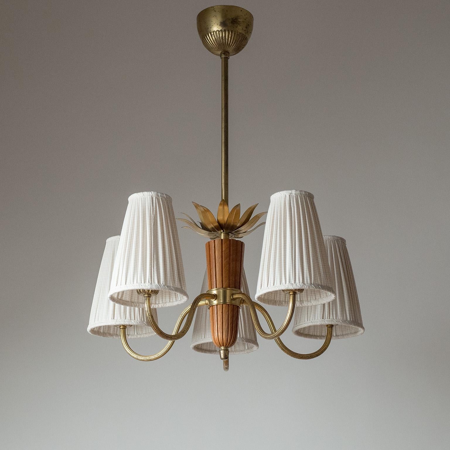 Delightful Swedish brass and wood chandelier, attributed to Hans Bergström for ASEA Belysning. Carved elm wood centerpiece with brass leaves decoration on top, and five ribbed brass arms with new custom shades. Nice original condition with patina on