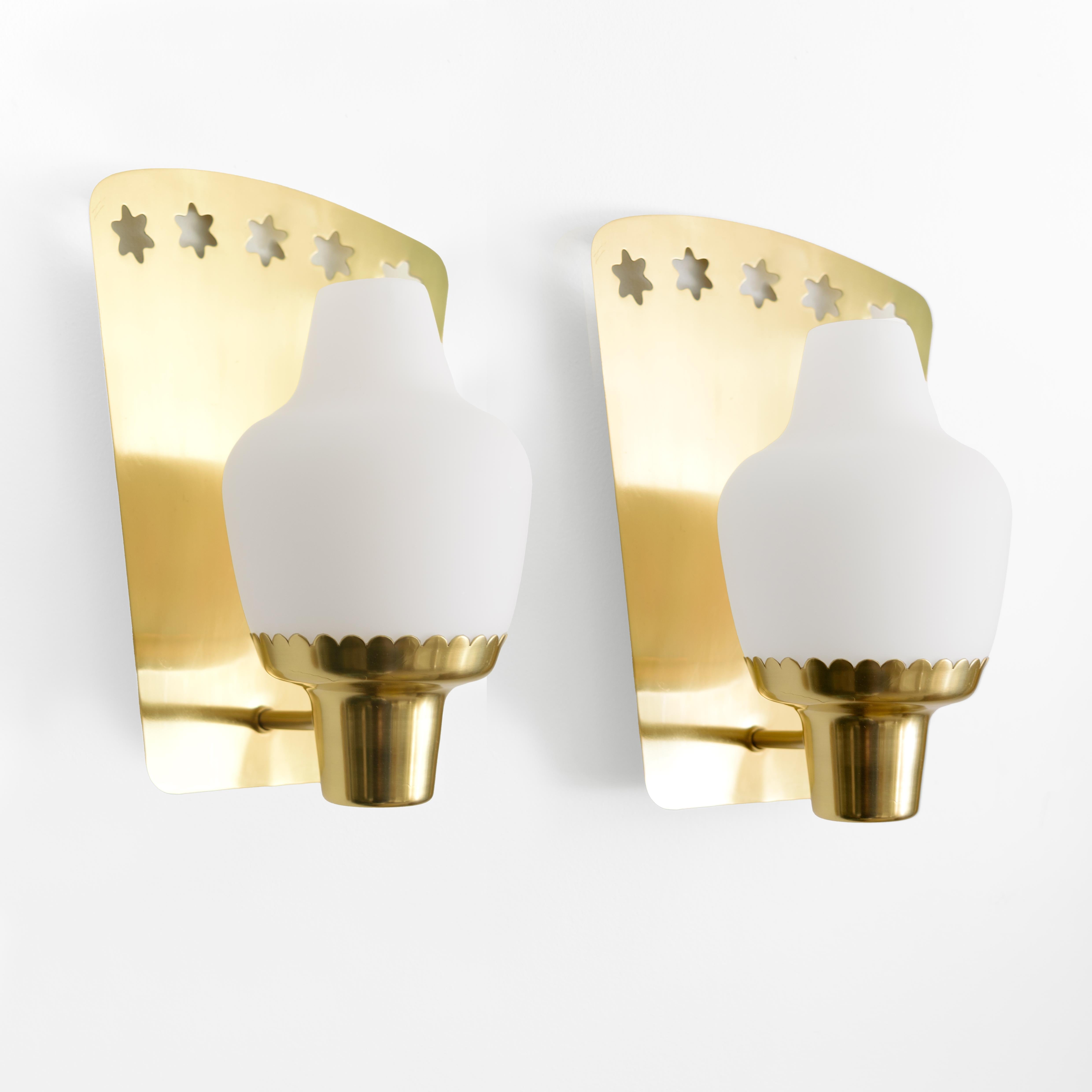 Pair of Scandinavian Modern wall sconces in polished brass designed by Hans Bergström for Ateljé Lyktan, Sweden circa 1950. The backplates are curved bodies with five cutouts with 6 points. Each has an arm with ends with a scallop edge which