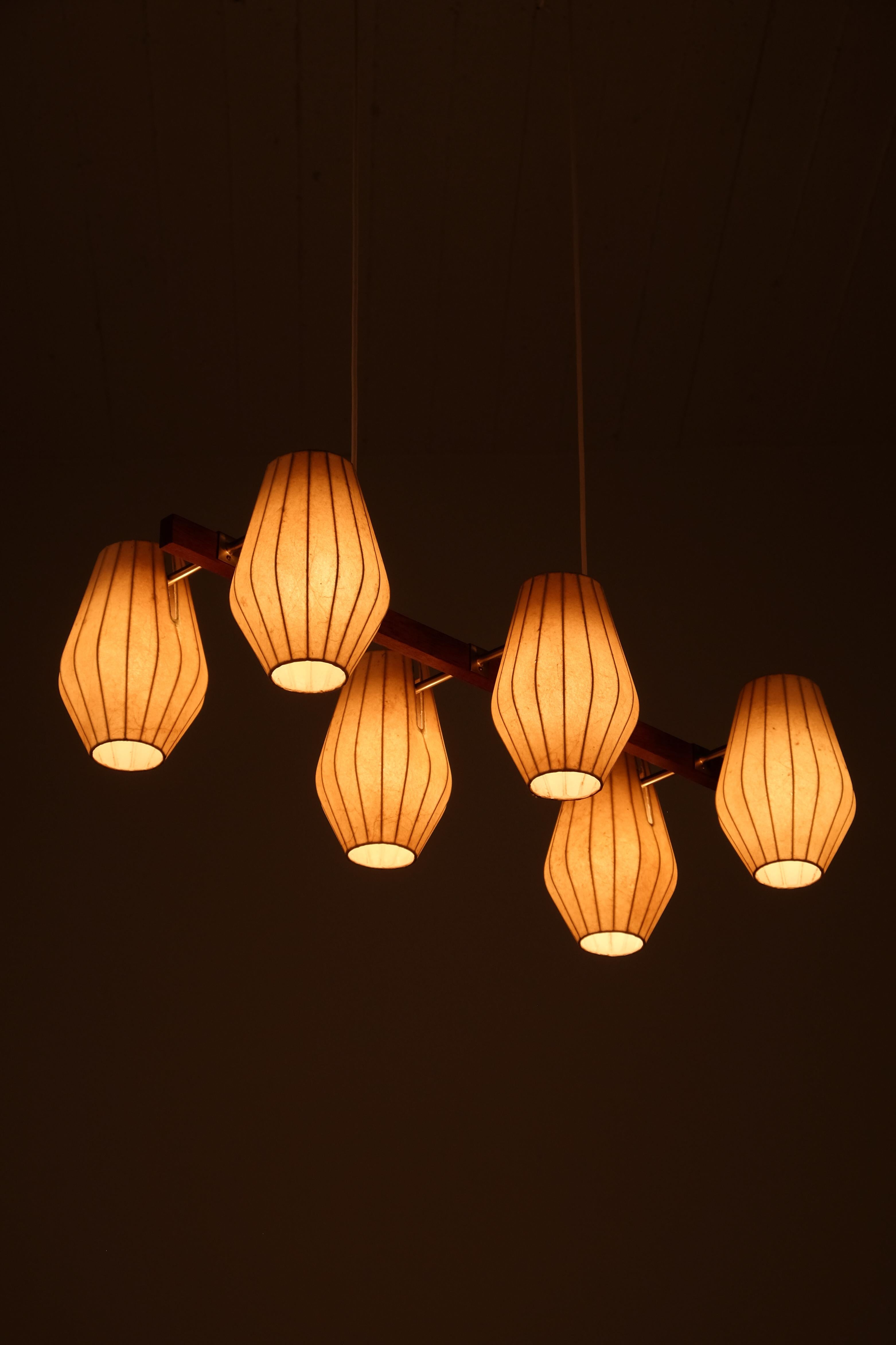 A stunning and rare ceiling lamp designed by Hans Bergström in the 1950s with a refined combination of materials: a teak frame, elegant brass fittings, and six beautifully shaped shades made of sprayed plastic. The organic form and warm tones create