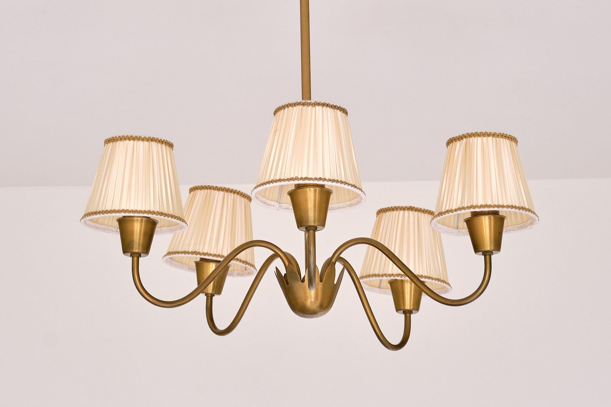 This rare five-arm chandelier was designed by Hans Bergström and produced by Ateljé Lyktan in Sweden during the 1950s.

The design is crafted entirely in brushed brass, which has developed a beautiful and even patina over time. The five curved arms