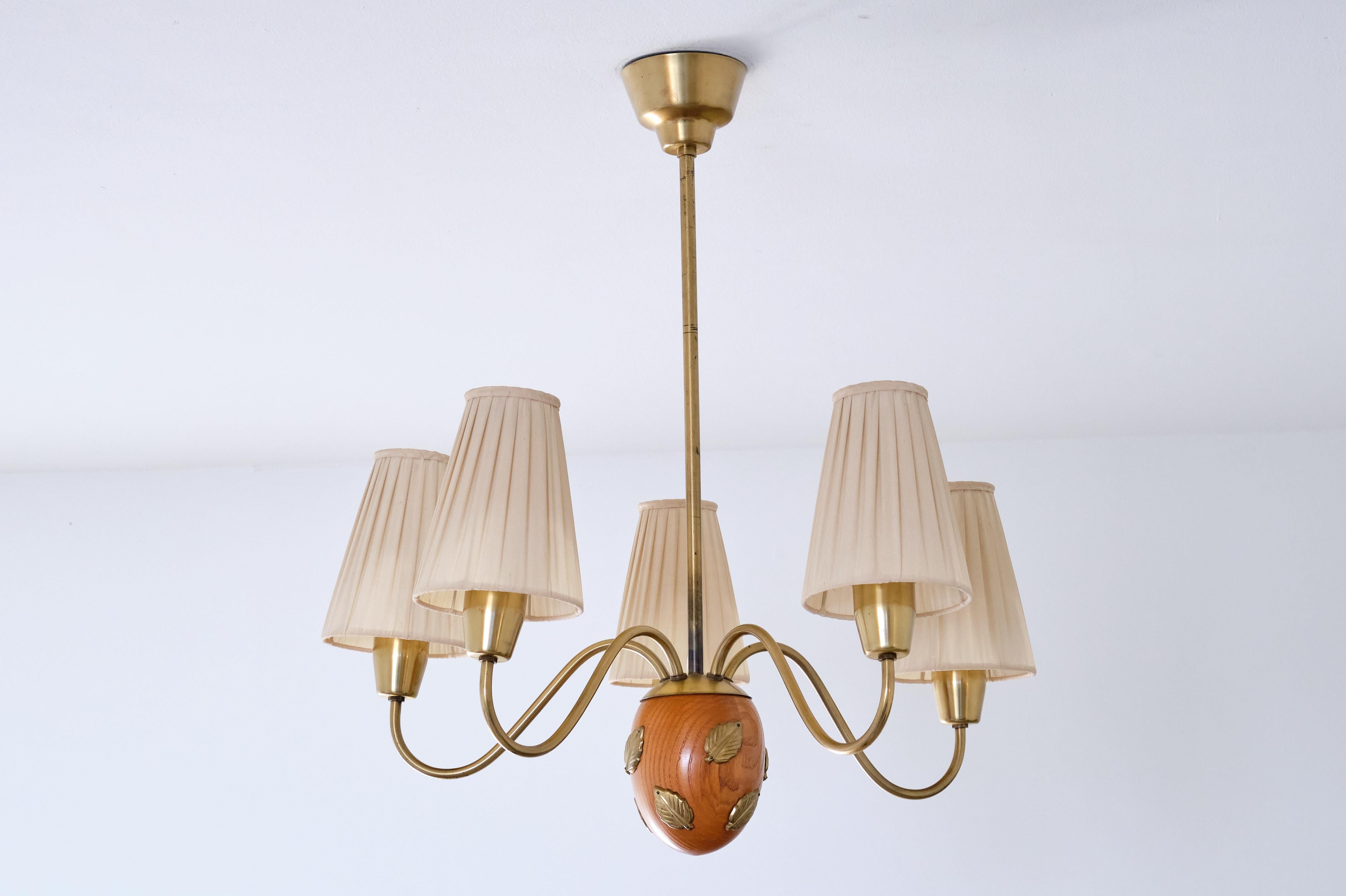 This rare five arm chandelier was designed by Hans Bergström and produced by his company Ateljé Lyktan in the late 1940s. This particular model was numbered '10/5'.

The chandelier features five curved brass arms mounted on top of a sculptural