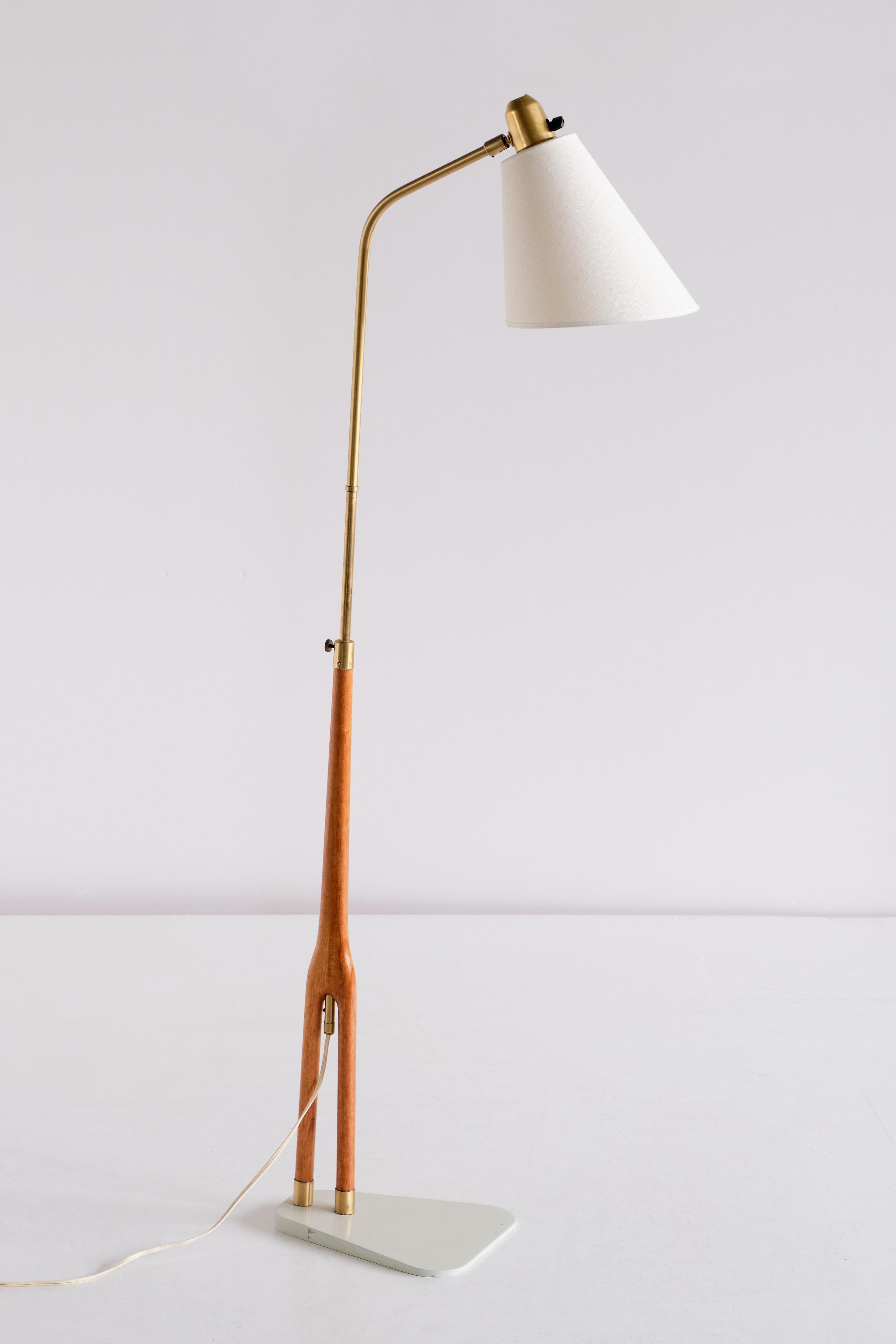 This striking floor lamp was designed by Hans Bergström and produced by ASEA in Sweden in the early 1950s. A very rare and elegant model by one of the masters of Swedish Modern lighting.

The two-legged teak and brass frame stands on metal base in
