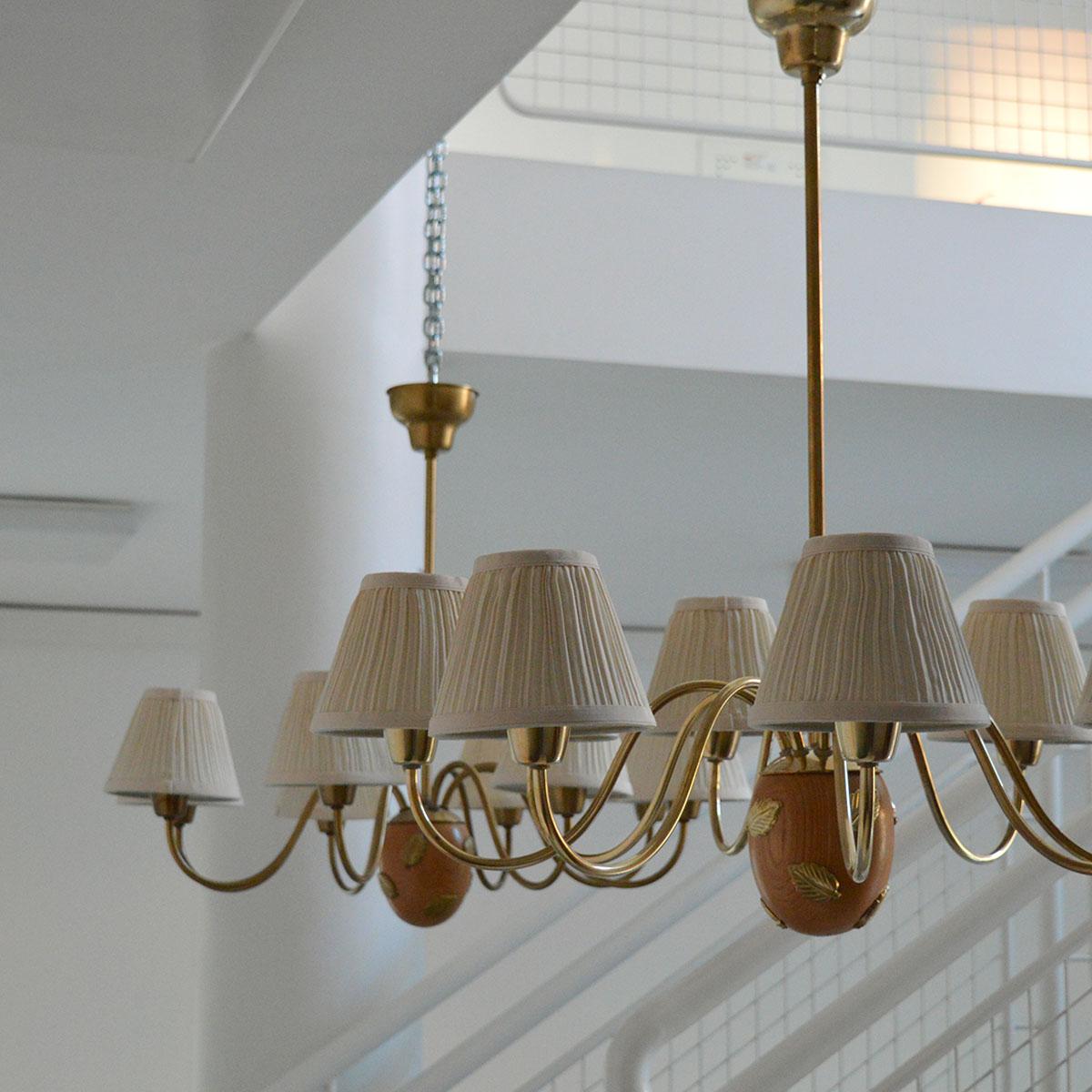 Large 8-arm chandelier in brass and wood, model 10/8, designed by Hans Bergström and produced by Ateljé Lyktan in Sweden, 1940s.

Designed by the Swedish architect and designer Hans Bergström, this chandelier features eight curved brass arms and a