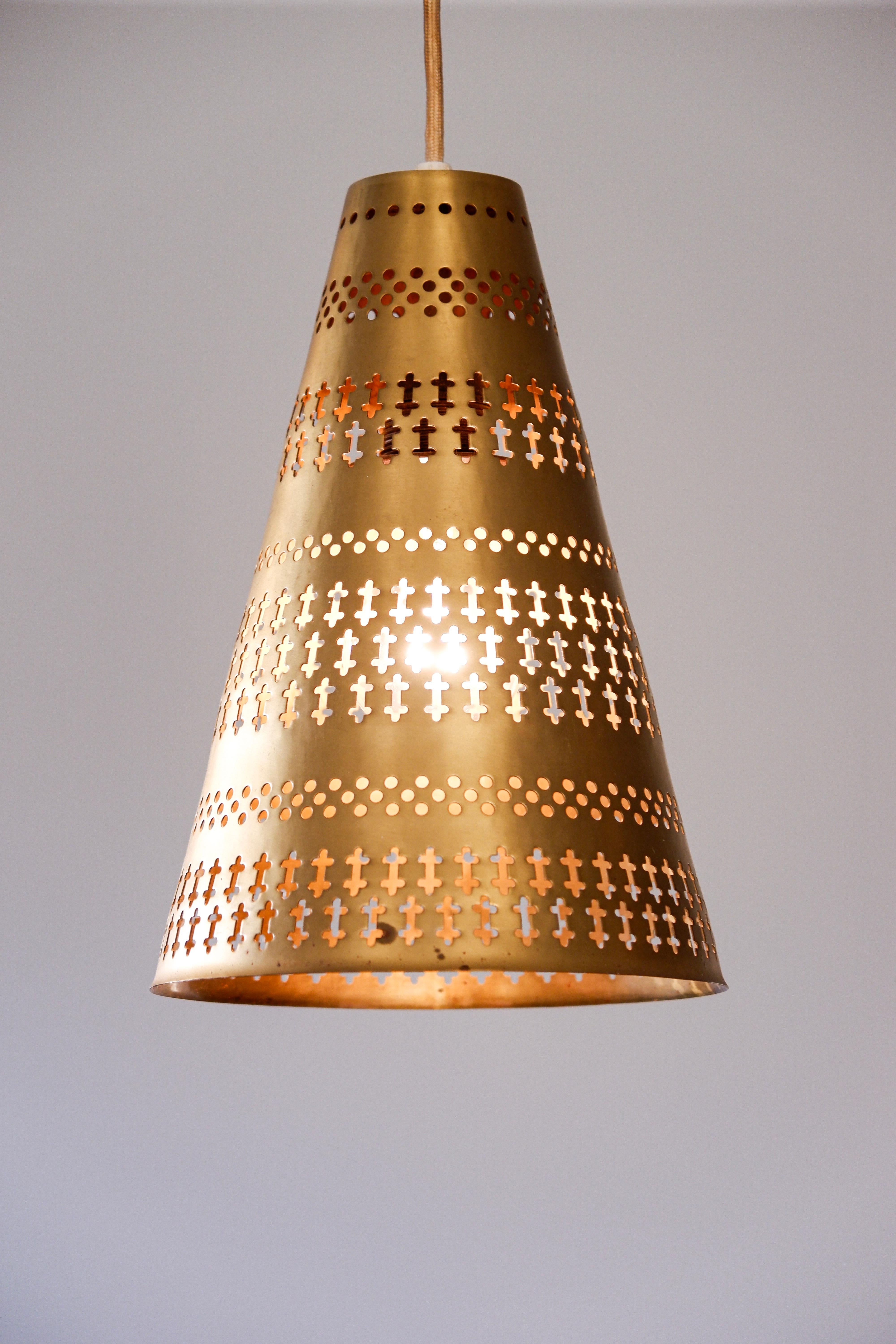 Pair of Hans Bergström perforated light designed by the artist in the 60's and produced by Ateljé Lyktan in the same time. The lamps are made in solide perforated brass that give a really poetic and impressive lights when there are lighted up. The