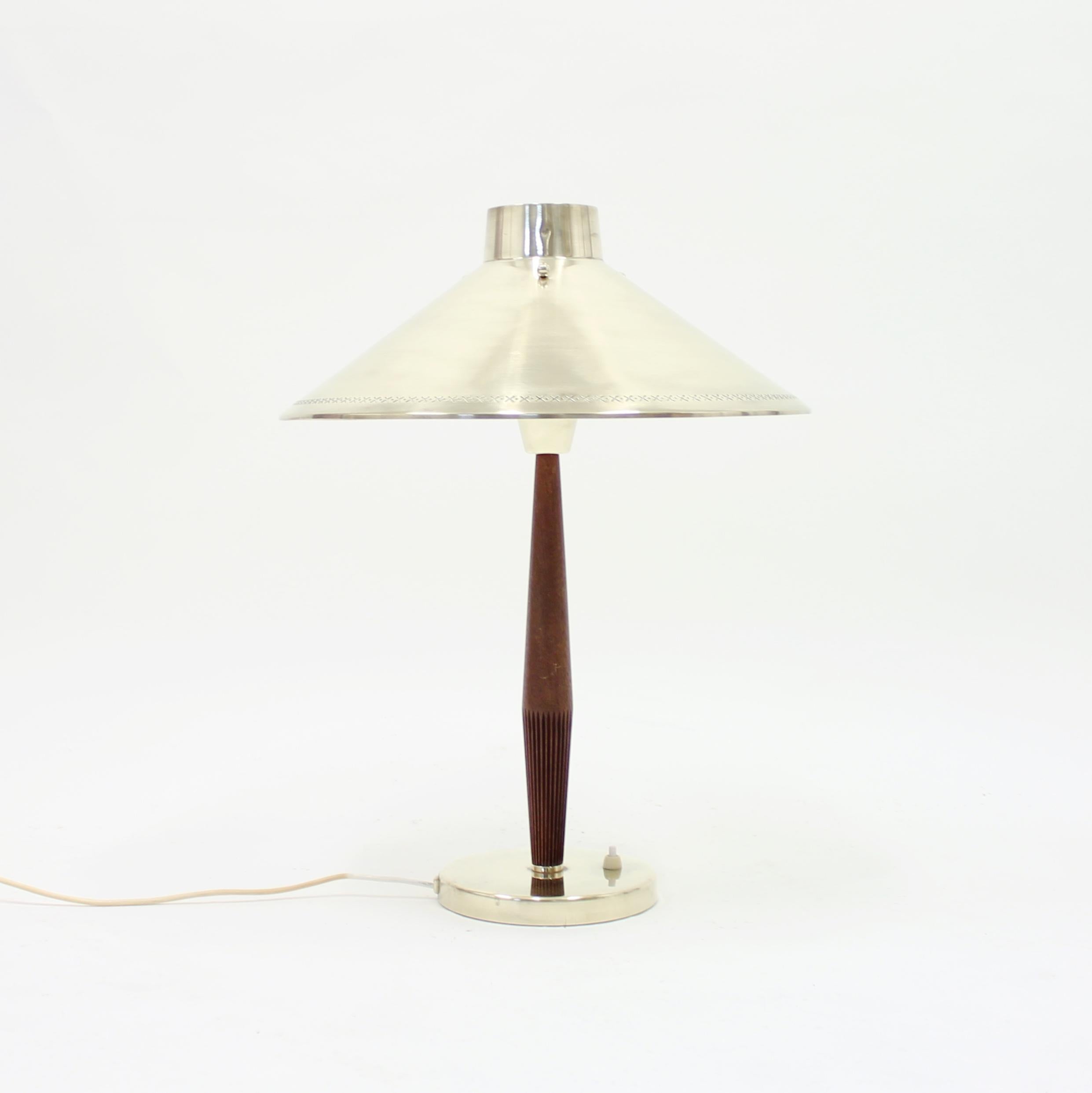 Teak and brass table lamp designed by Hans Bergström for ASEA in the 1950s. The shade is hold in place by three globe brass screws that sits on top of the shade as a decoration. Overall in a good vintage condition. All the brass has been polished