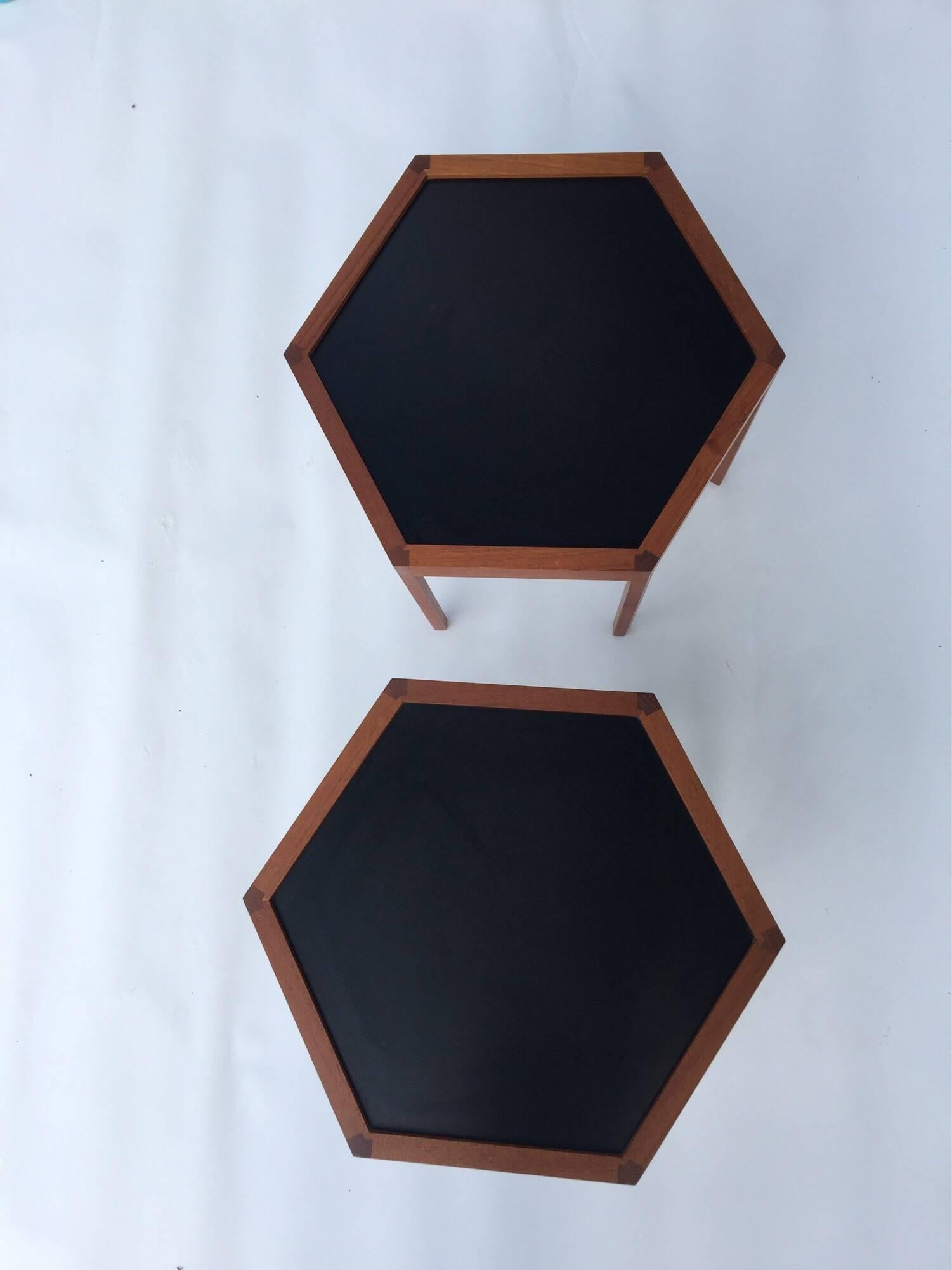 Hexagonal teak side tables by Hans Andersen for Artek with black Formica tops exposed joinery accents the design branded to the reverse 