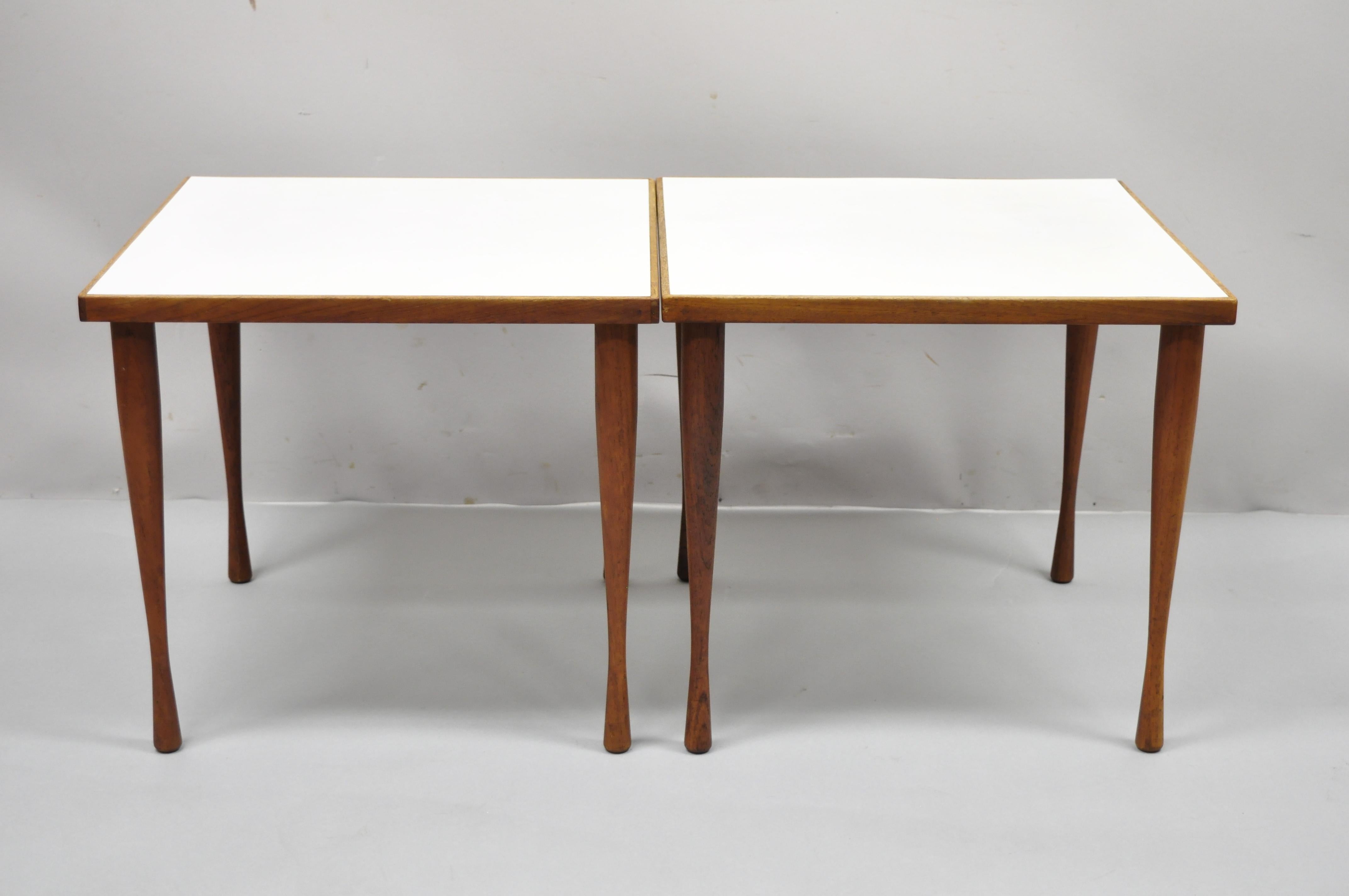 Hans C. Andersen teak wood white Formica tapered hour glass leg snack side tables - a pair. Item features hour glass teak wood tapered legs, white Formica top, beautiful wood grain, original label, clean modernist lines, great style and form, Circa