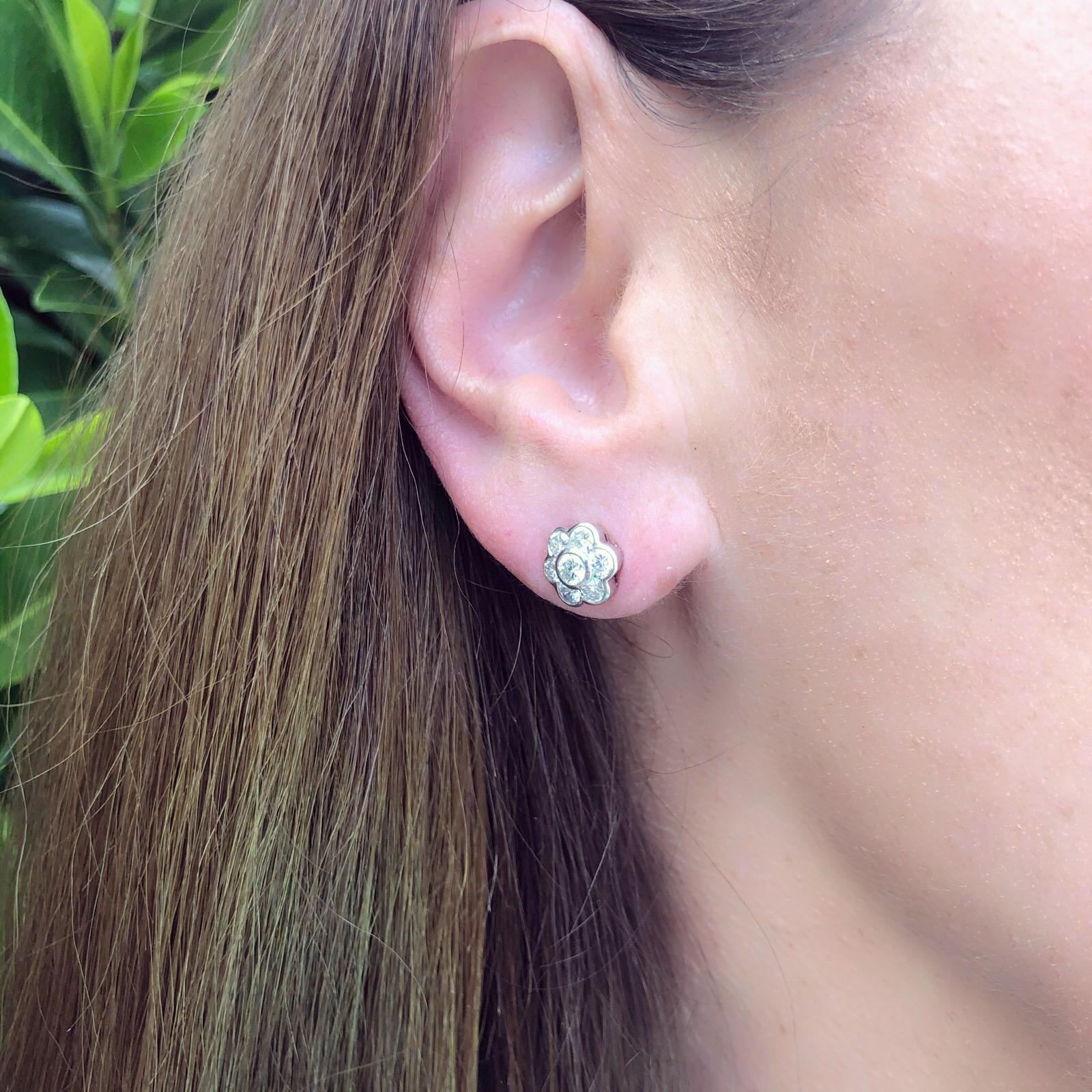 Perfect for everyday wear, these 18k white and yellow gold flower style earrings are bezel-set with 14 sparkling round brilliant-cut diamonds, weighing in total 1.59cts. The earrings weigh 5.50 grams and measure 3/8