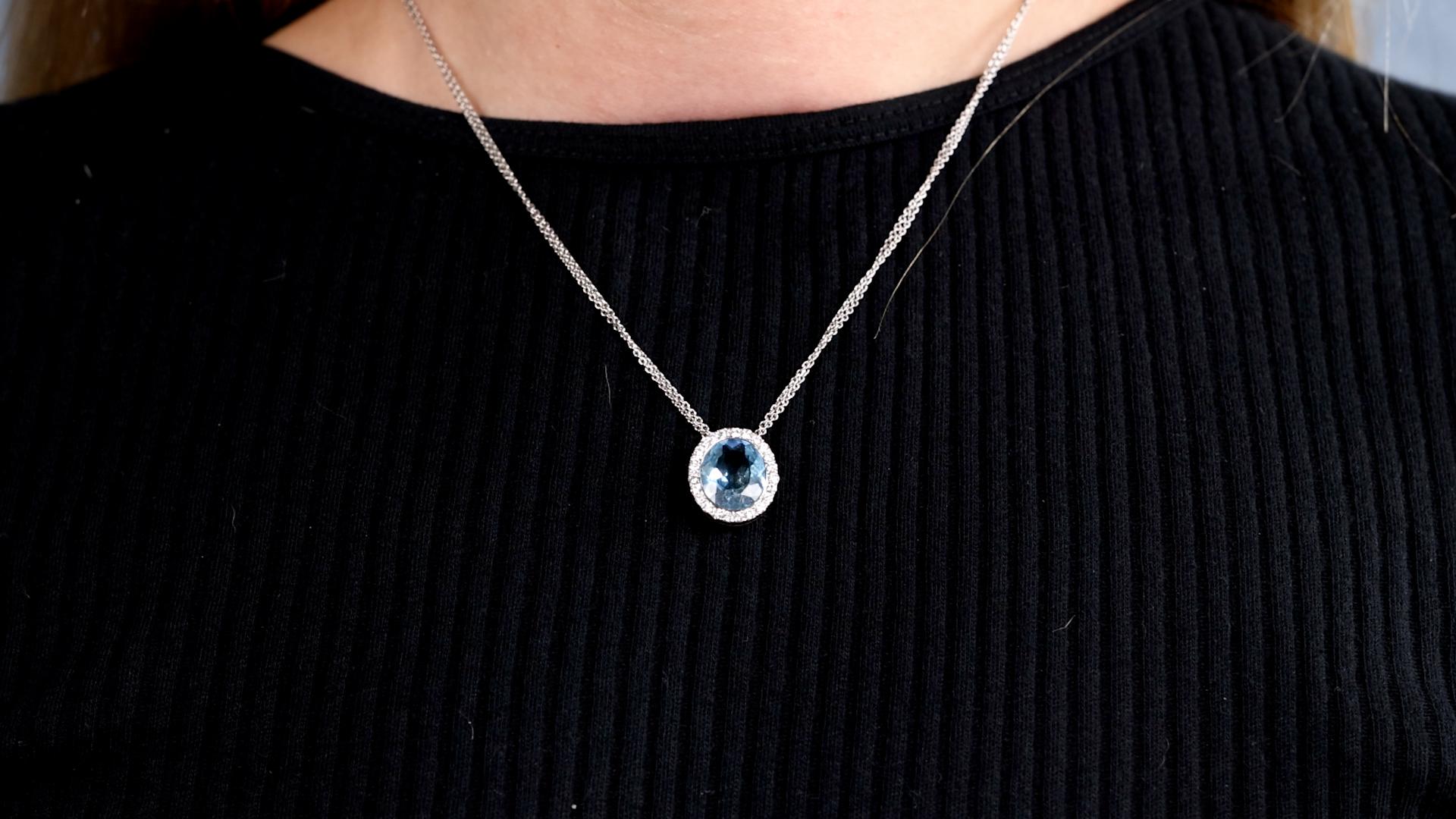 One Hans D. Krieger Aquamarine Diamond 18k White Gold Pendant Necklace. Featuring one oval brilliant cut aquamarine weighing approximately 4.20 carats. Accented by 24 round brilliant cut diamonds with a total weight of approximately 0.60 carat,