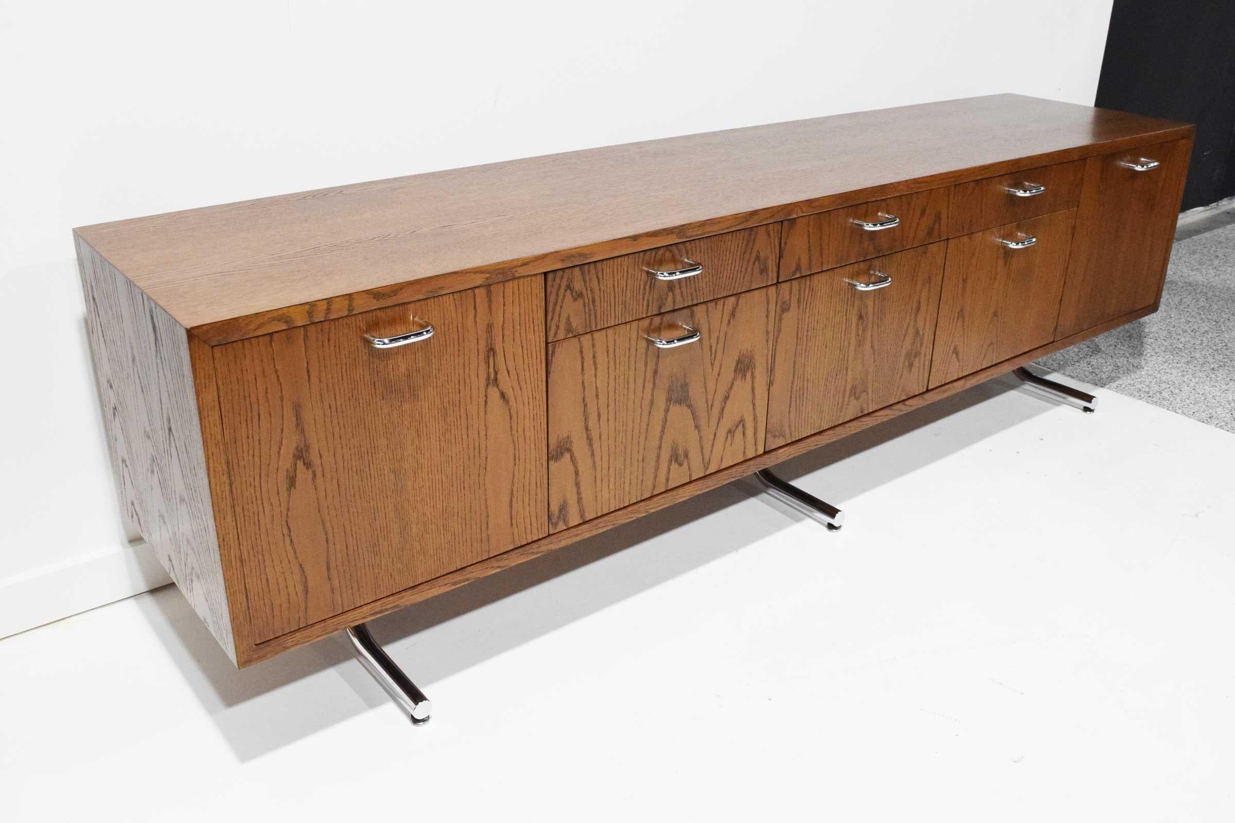 We are fairly sure this is by Hans Eichenberger. The credenza is extremely well made with beautifully grained oak and is finished in the back for floating in room if desired. Stylized curved steel chromed legs and steel chromed pulls. Plenty of