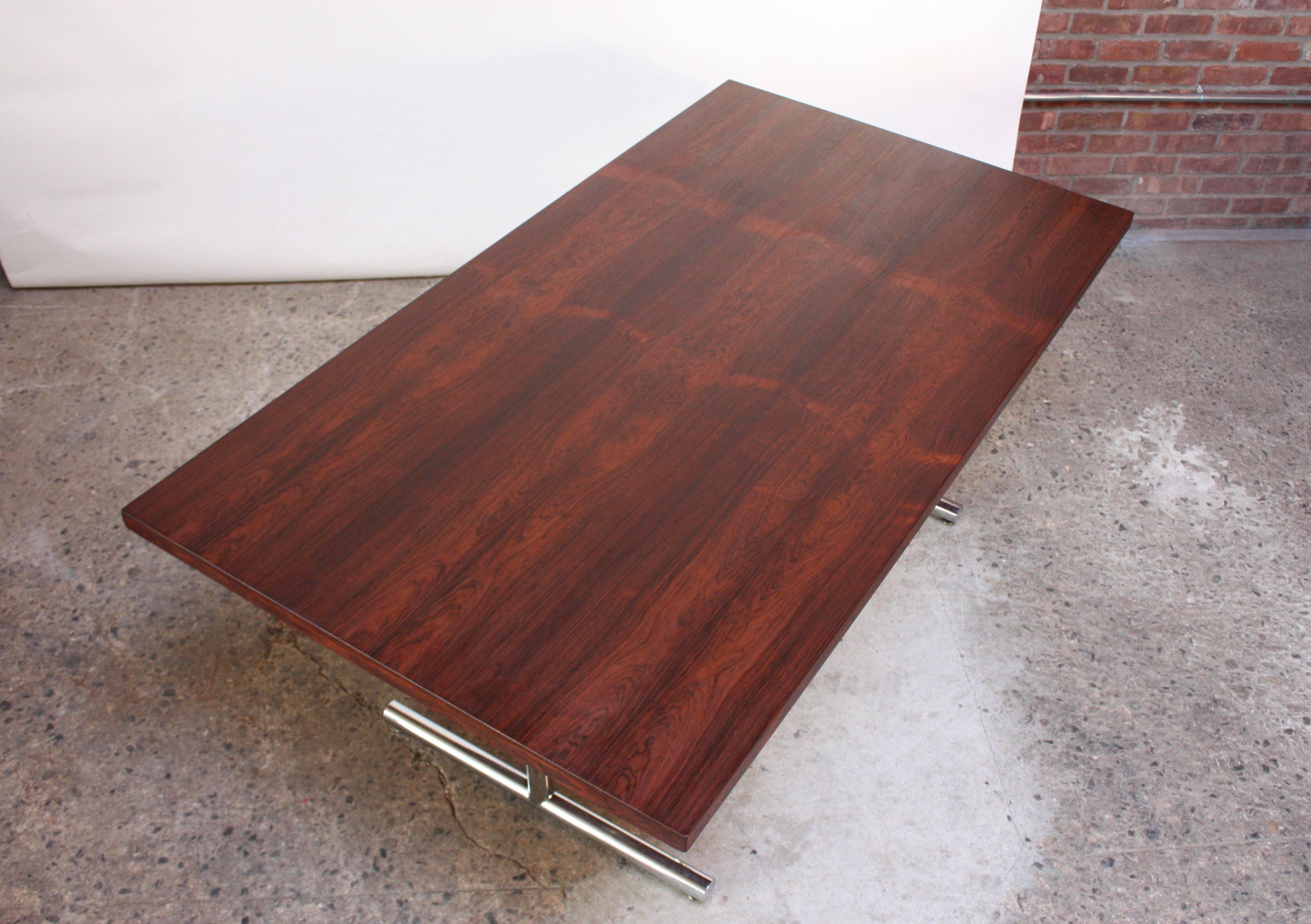 'Omega' writing or dining table designed by Hans Eichenberger for Haussmann & Haussmann of Switzerland and distributed by Stendig. Composed of a bookmatched rosewood veneer top and tubular chrome bases.
Chrome has been cleaned and polished and