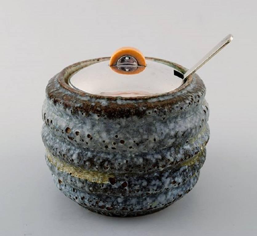 Hans Hansen (1884-1940) and Bode Willumsen (1895-1987).
Unique marmalade jar of bluish glazed stoneware, with lid
and marmalade spoon by Hans Hansen of hammered sterling silver.
Signed 