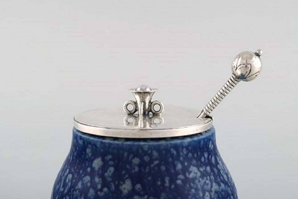 Hans Hansen (1884-1940) and Bode Willumsen (1895-1987).
Unique marmalade jar of bluish glazed stoneware, with lid and marmalade spoon by Hans Hansen in sterling silver.
Signed 