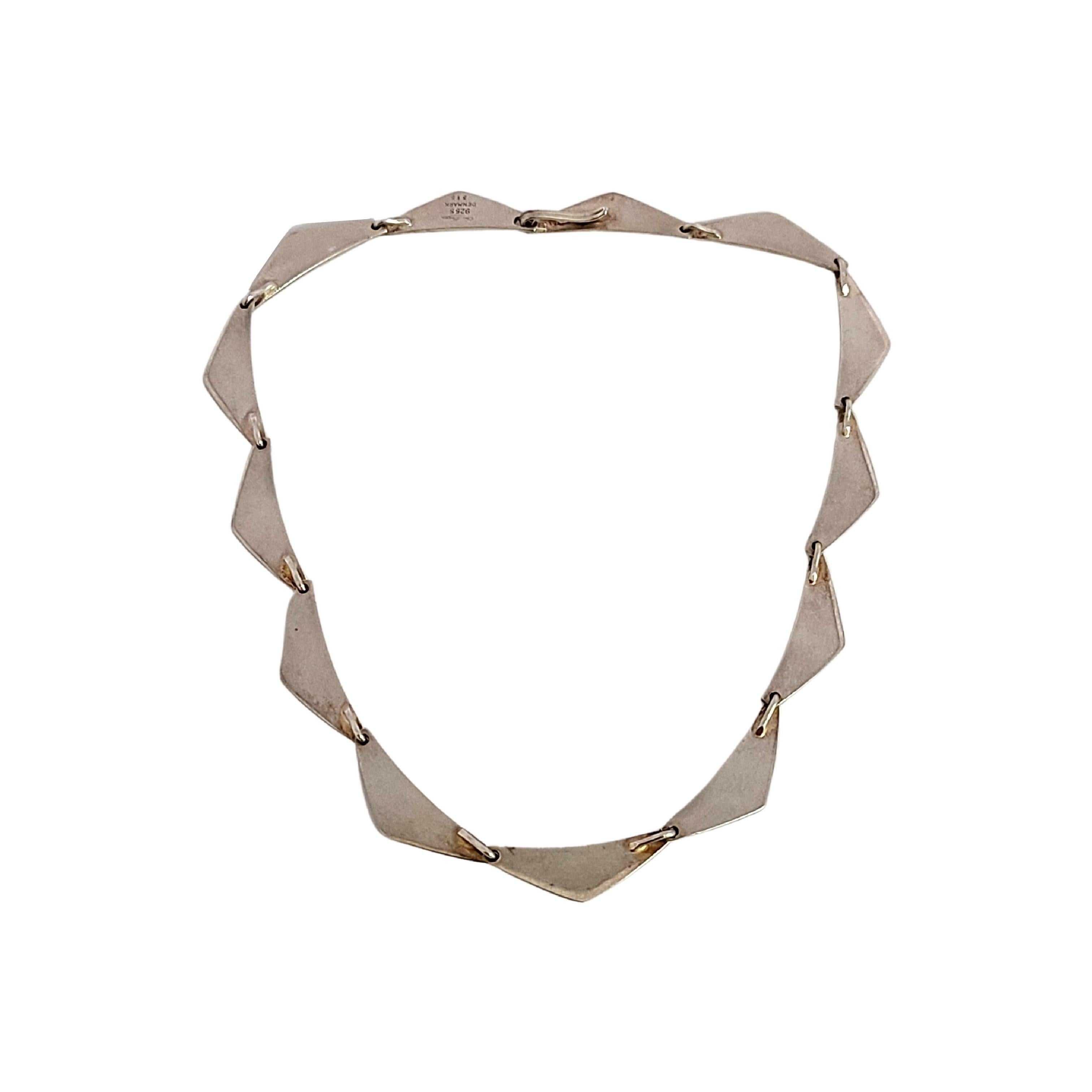 Sterling silver peaks necklace by Hans Hansen, design #315.

This necklace features slightly curved triangular links with a hook closure.

Measures 15 3/4