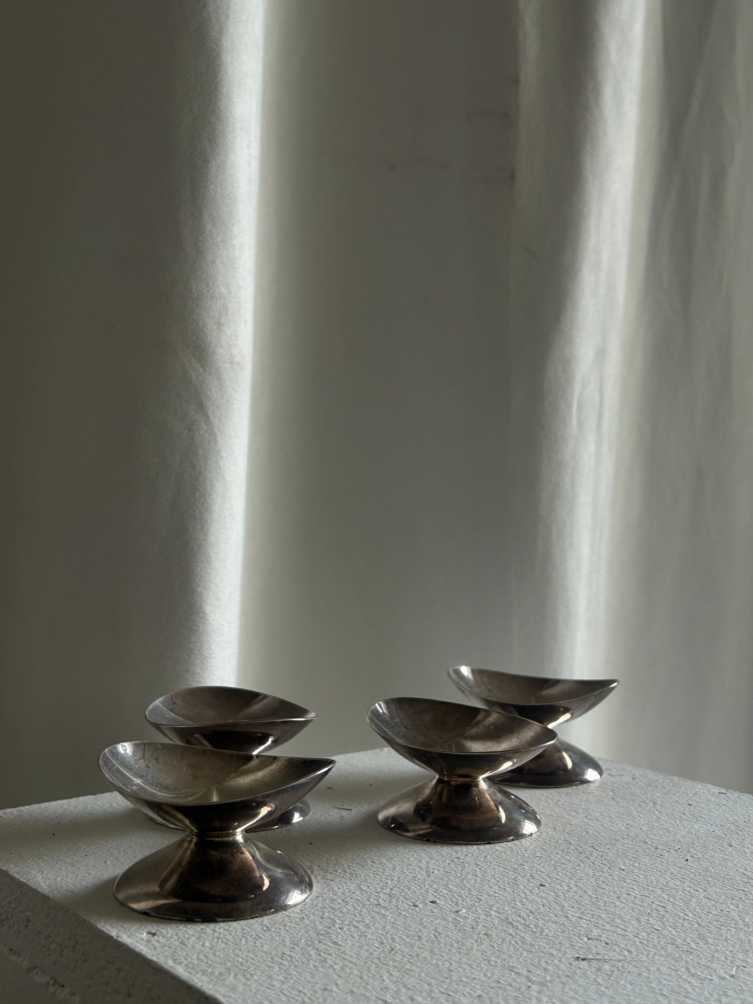 Ensemble de quatre bougeoirs en argent massif du célèbre orfèvre danois Hans Hansen, chacun présentant le minimalisme et la précision sculpturale caractéristiques de l'atelier. La forme géométrique épurée - un jeu subtil de courbes et de plans -