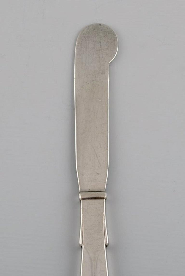 Hans Hansen silverware no. 7. Art Deco butter knife in all silver 830. Dated 1934.
Measure: Length: 14.2 cm.
In excellent condition.
Stamped.
Our skilled Georg Jensen silversmith/goldsmith can polish all silver and gold so that it appears new.