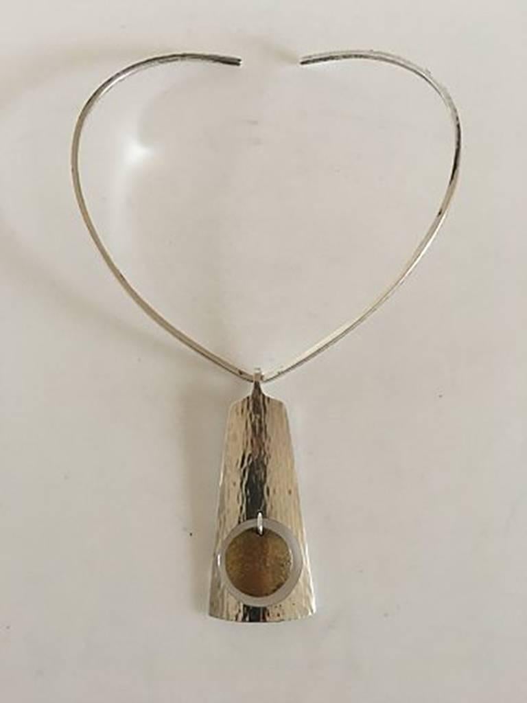 Hans Hansen Sterling Silver Necklace and Pendant. The neckring measures 13 cm Ø / 5 1/8 in. Pendant measures 8.5 cm x 3.5 cm / 3 11/32 in. x 1 3/8 in. Combined weight of 56 g / 2 oz.
Designed by Bent Gabrielsen