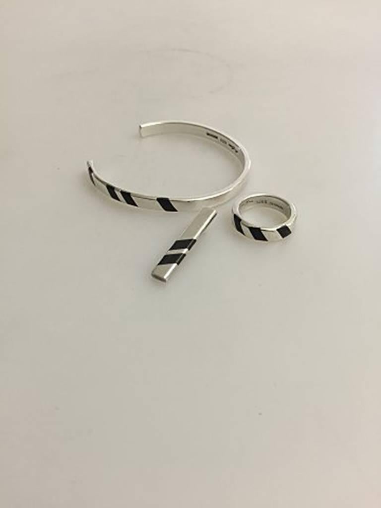 Hans Hansen Sterling Silver Ring, Armring and Pendant with Black Enamel
Armring weighs 20 g / 0.7 oz and measures 5.6 cm dia. / 1 13/16 in. 
Ring weighs 7.6 g / 0.26 oz. Ring Size 53 1/2 / US 6 1/2 
Pendant weighs 4.3 g / 0.15 oz. and measures 3 cm