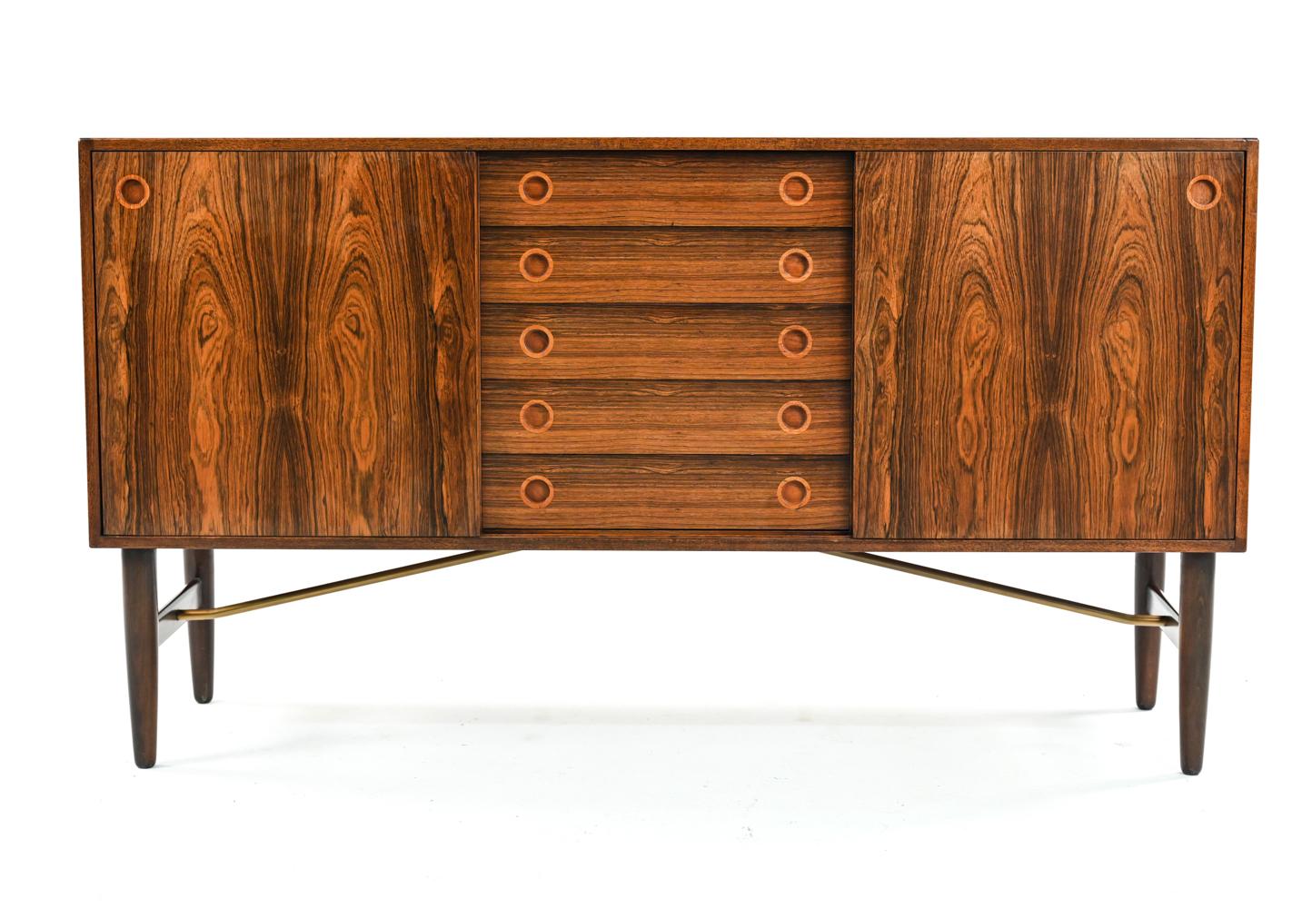 A handsome Scandinavian modern sideboard designed by Hans Hove & Palle Petersen. Produced by Christian Linneberg in Denmark, c. 1960's. Featuring round drawer pulls, tapered legs, bookmatched rosewood veneer, and a metal stretcher. Quality of work