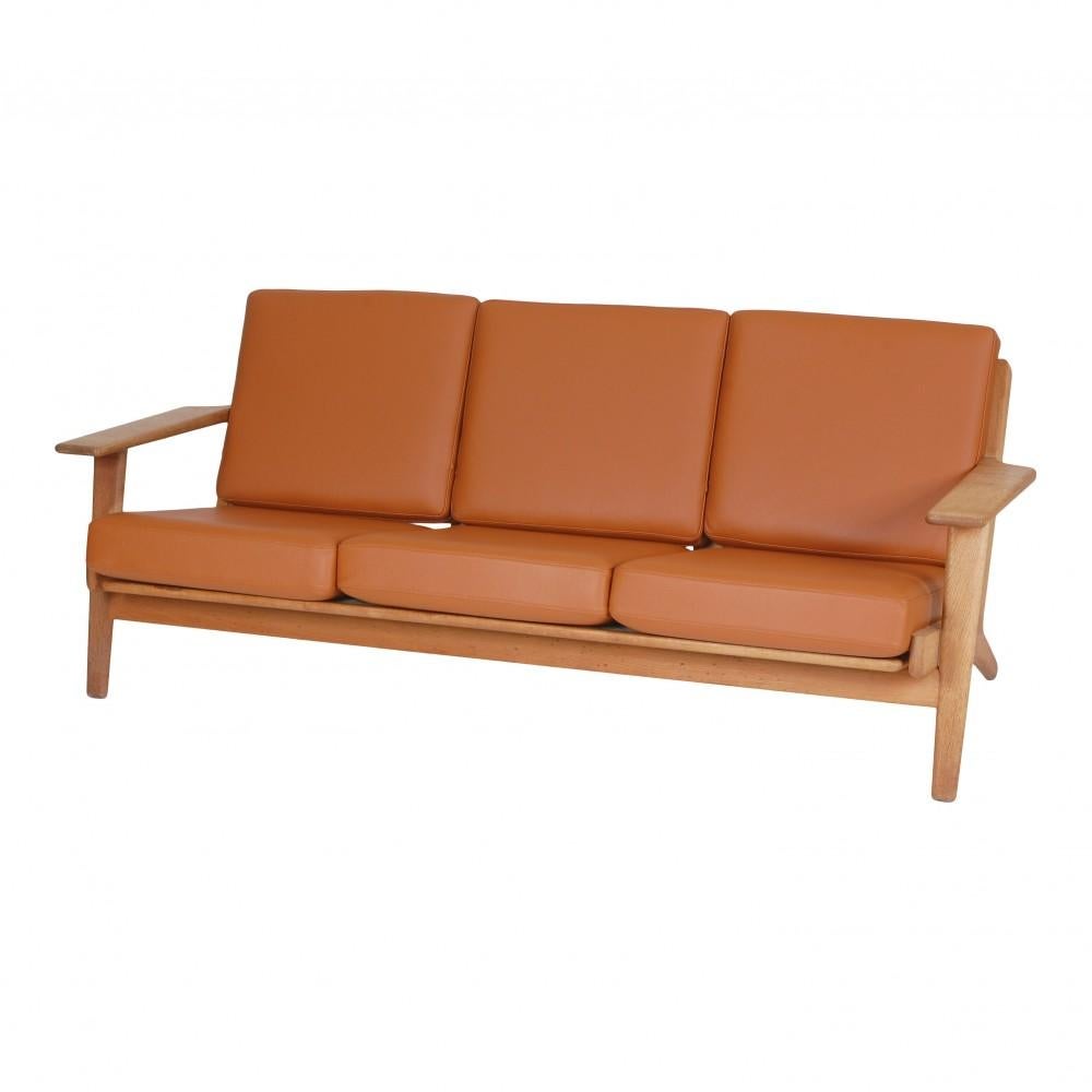 Hans J. Wegner 3. seater sofa model Ge-290/3 with a frame of oak, and mounted with new foam cushions upholstered with cognac bison leather. 