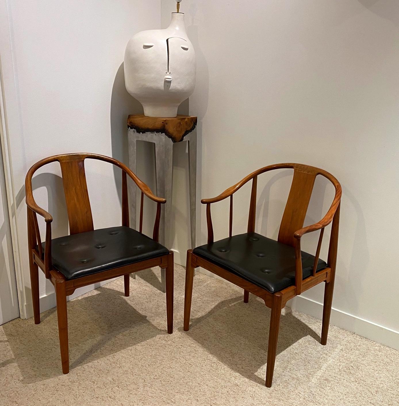 Hans J. Wegner:
 A pair of walnut armchairs “China chairs”. The China chair was designed by Hans J. Wegner in 1944.
Loose seat cushion upholstered with black leather, fitted with buttons. Model 4283. 
Manufactured 1977 by Fritz Hansen with