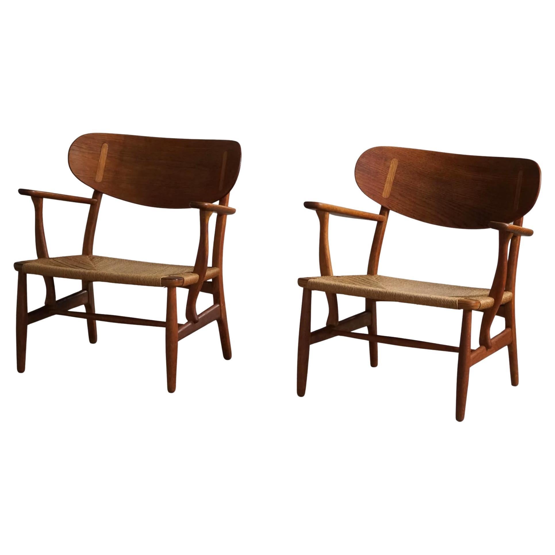 Hans J. Wegner, Ein Paar CH22-Loungesessel aus Eiche, dänische Moderne, 1950er Jahre