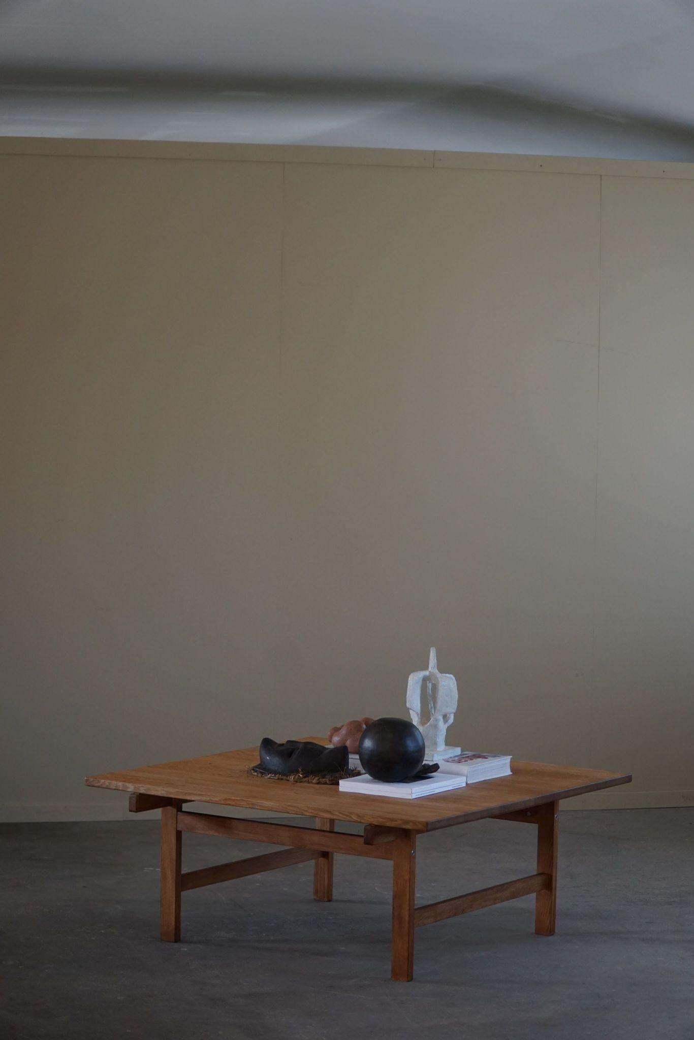 Cette table basse carrée, conçue par Hans J. Wegner pour Andreas Tuck dans les années 1960, est une pièce moderne danoise du milieu du siècle, fabriquée en chêne massif. La table présente des lignes épurées et un design minimaliste, soulignant le