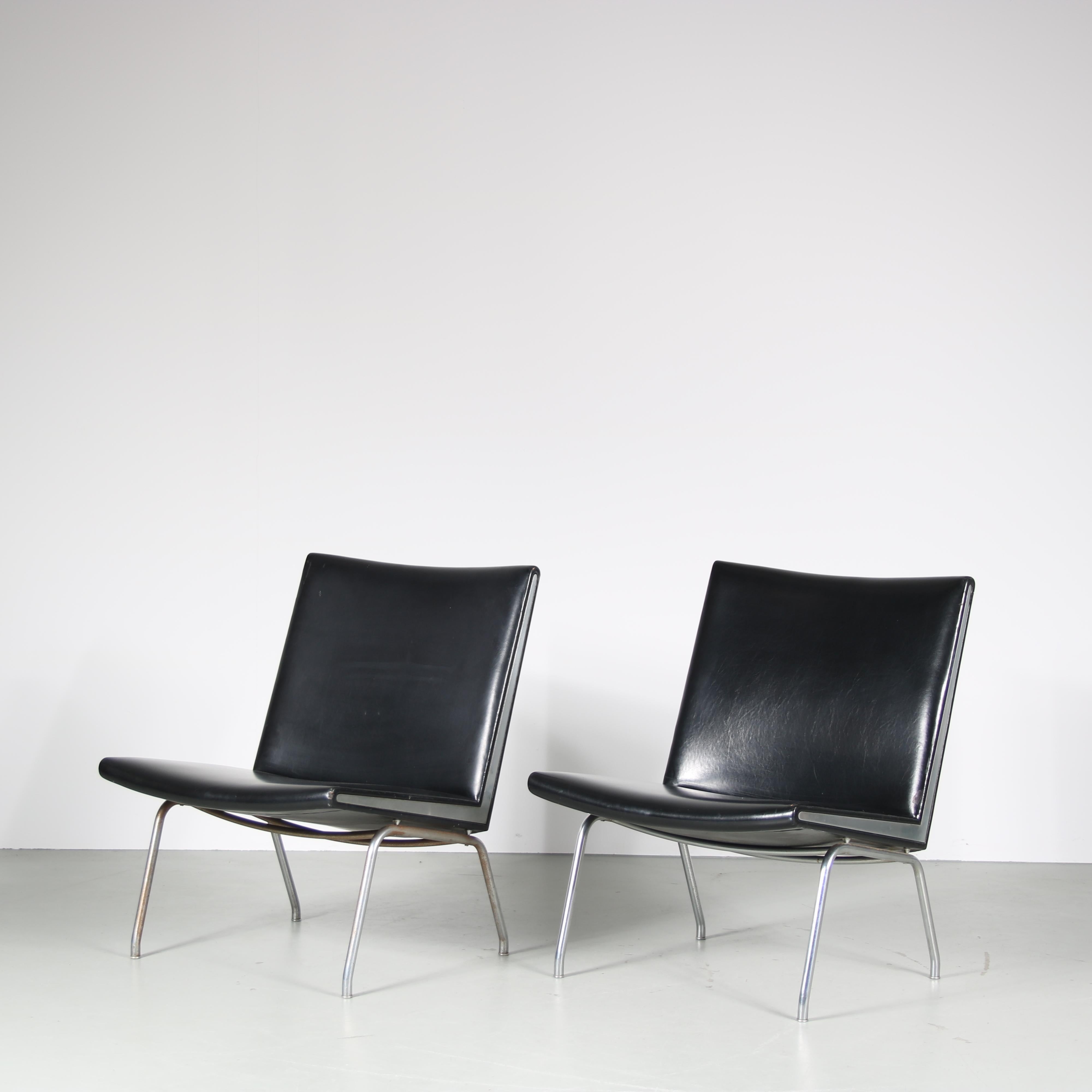 Années 1960 Paire de chaises longues sur socle en métal chromé avec revêtement en skaï noir et détails chromés, modèle Airport / Hans J. Wegner / AP Stolen, Danemark

Une paire de chaises 