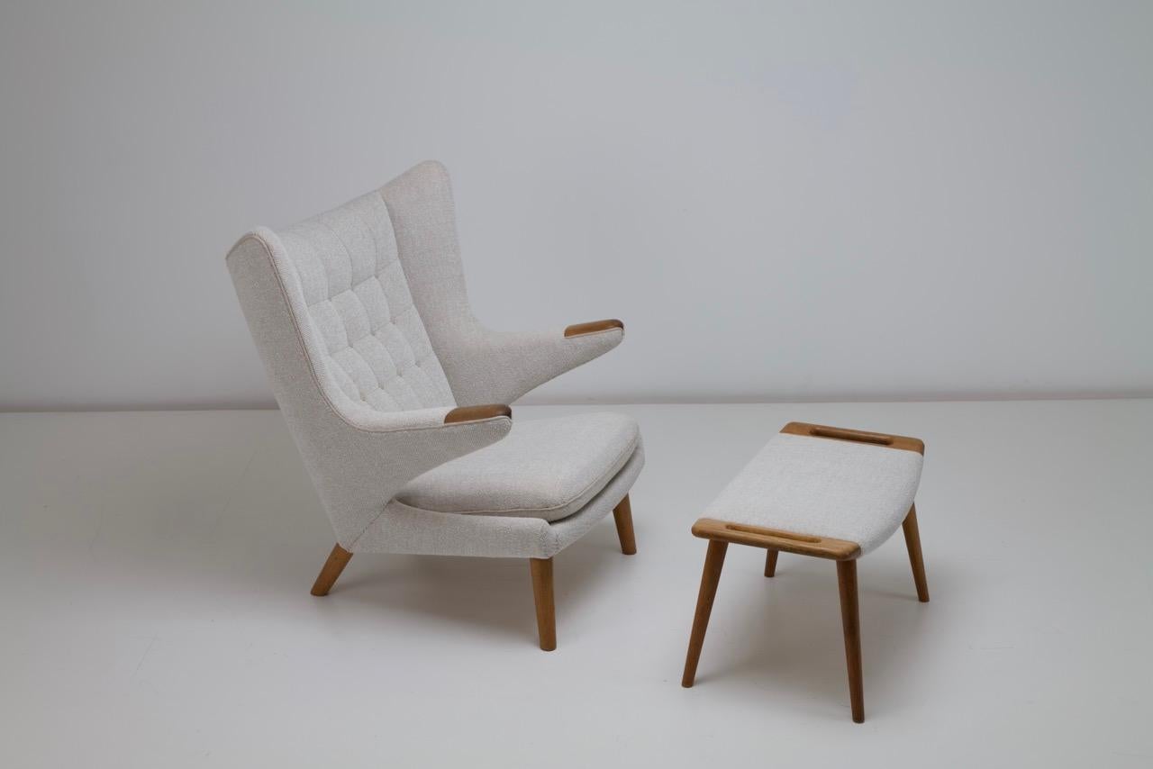 We have for sale a Papa Bear Chair and footstool designed by Hans Wegner for AP Stolen. The paws and legs are finished in oak. This is a super comfortable chair. Stylistically the pieces can fit into many interiors. 

The chair and footstool have