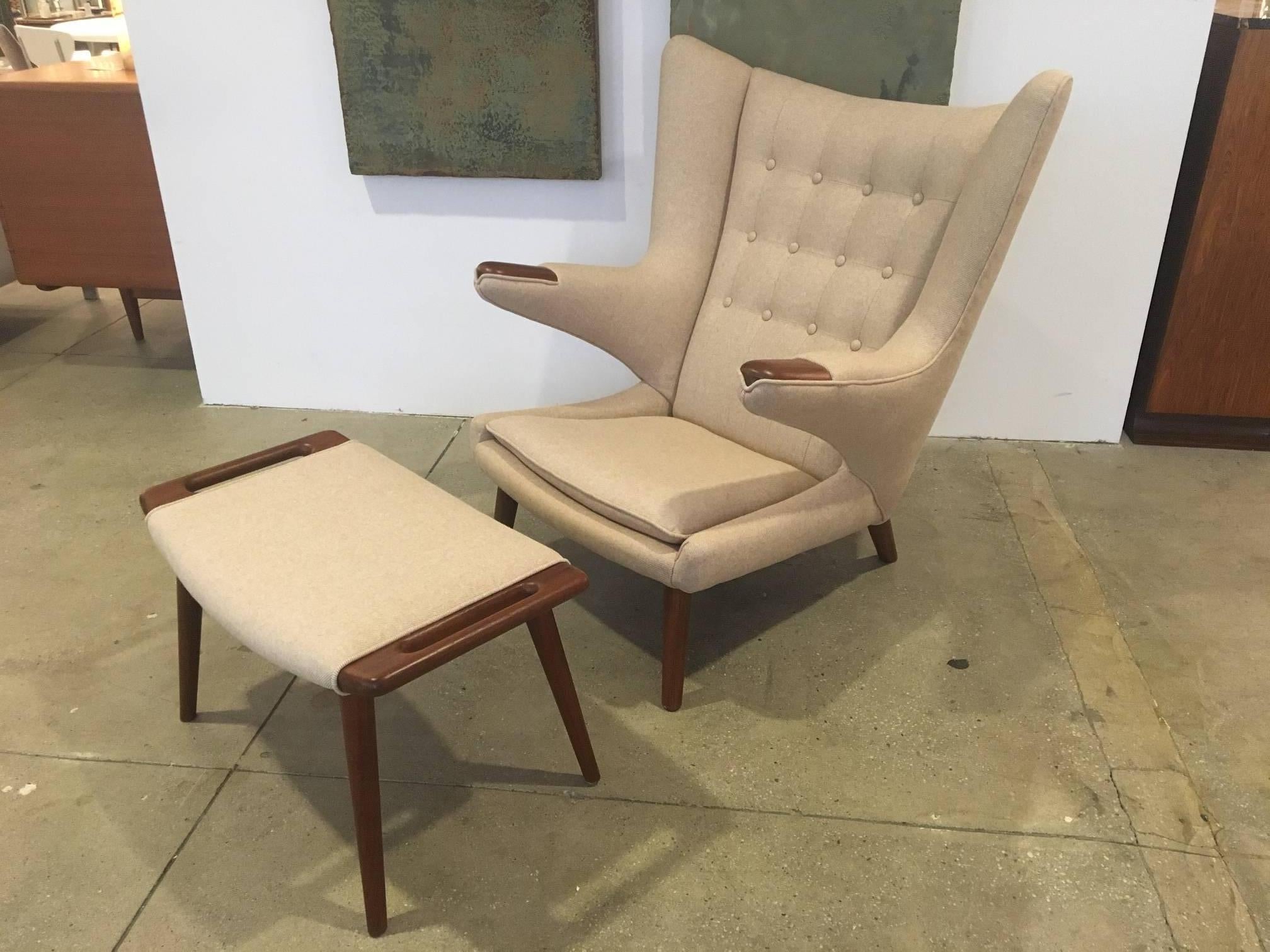 An original Papa Bear chair and stool by Hans Wegner, designed in 1951 and manufactured by AP Stolen as model AP19.
Both chair and stool have been newly upholstered in light beige herring bone wool fabric and polished with teak oil.  The stool