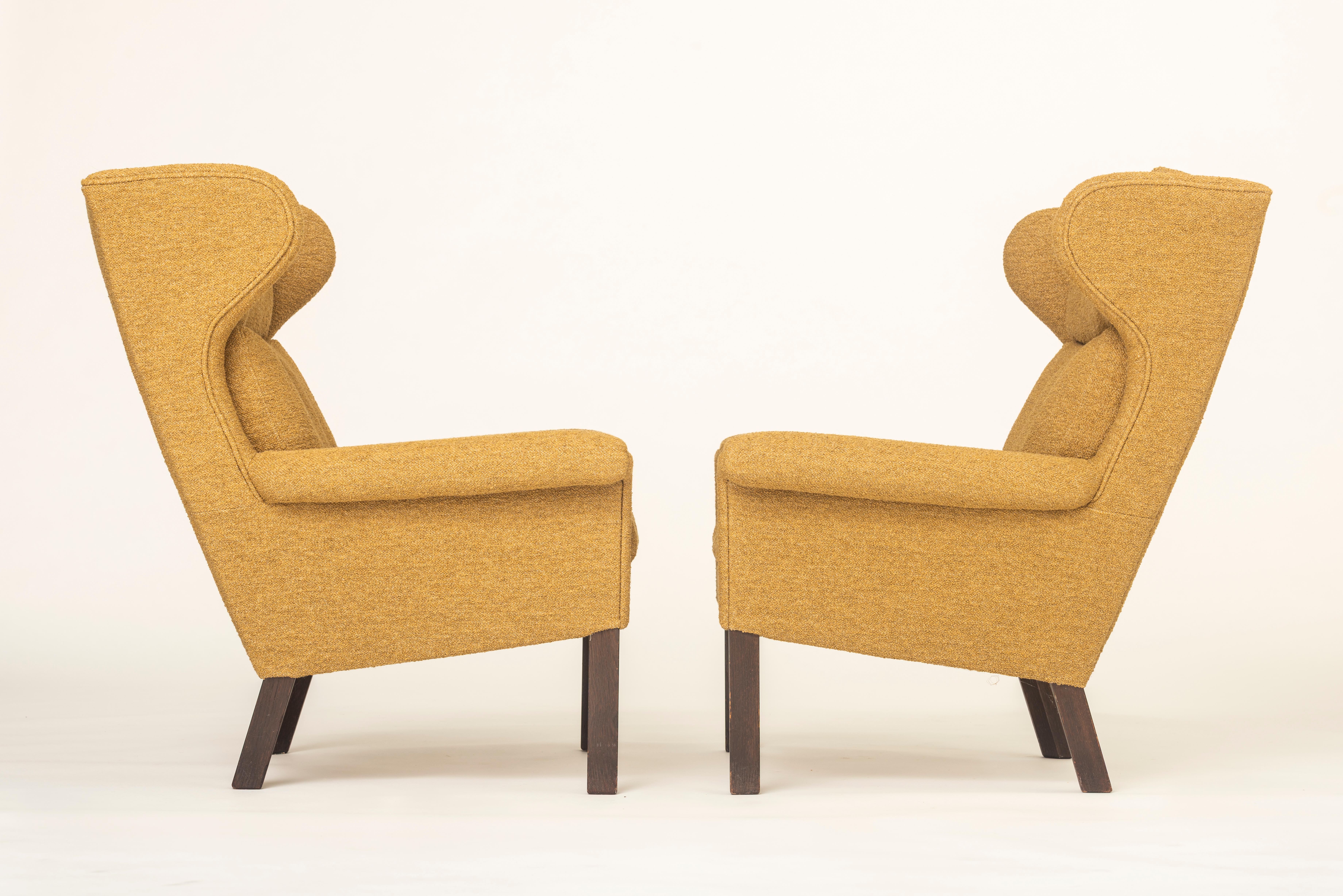 Raros sillones de salón con respaldo de ala fabricados por AP Stolen. Totalmente restaurado y retapizado en tejido boucle para muebles, cómodos brazos acampanados y patas de madera de roble teñida, diseñado por Hans Wegner para A.P. Robado a