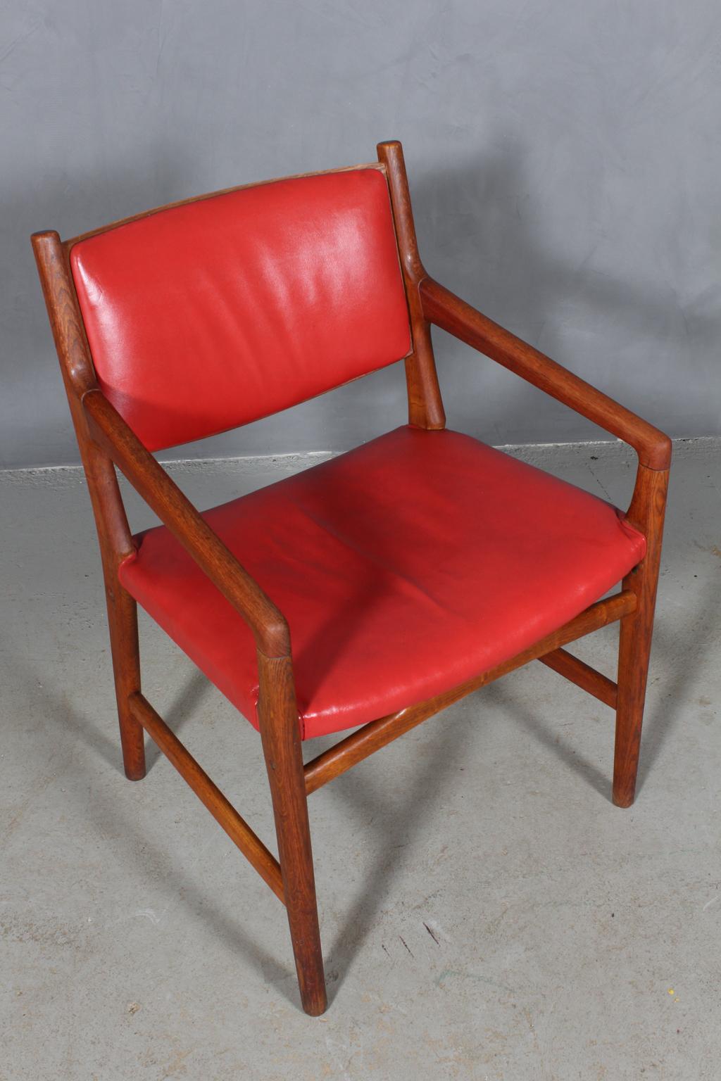 Hans J. Wegner armchair frame of oak and armrests of teak.

Seat and back original Upholstered with red patinated leather.

Made by Johannes Hansen in the 1950s for Magasin Du Nords shoe department. Therefore there are holes in the chair for