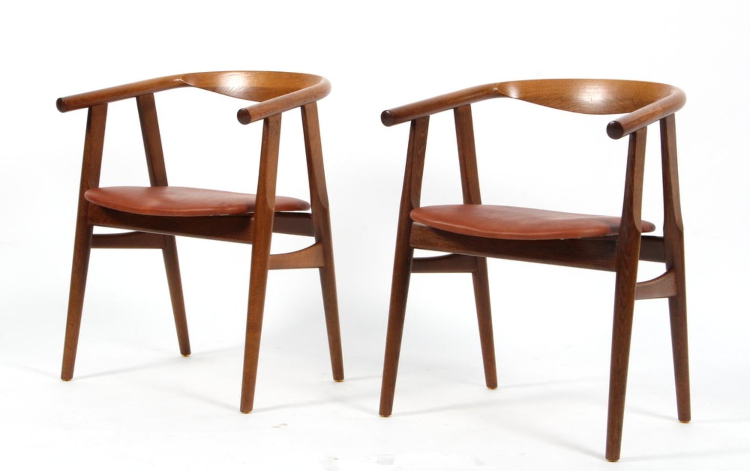 Hans J. Wegner armchairs in massive smoked oak.

New upholstered with cognac aniline leather.

Model GE-525, made by GETAMA.

Three chairs in total.