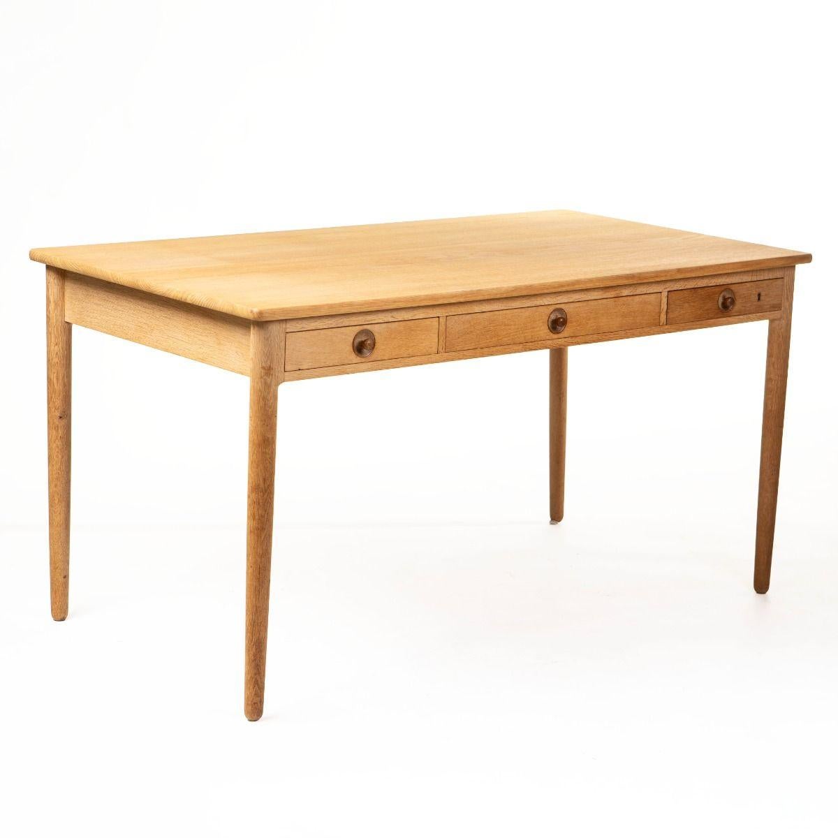 Elegant and timeless desk, model AT-305, designed by Hans J. Wegner in 1955 and crafted by Andreas Tuck.

Made of solid oak and fitted with three drawers – the right-hand drawer with its original lock and key, and the left-hand drawer with practical