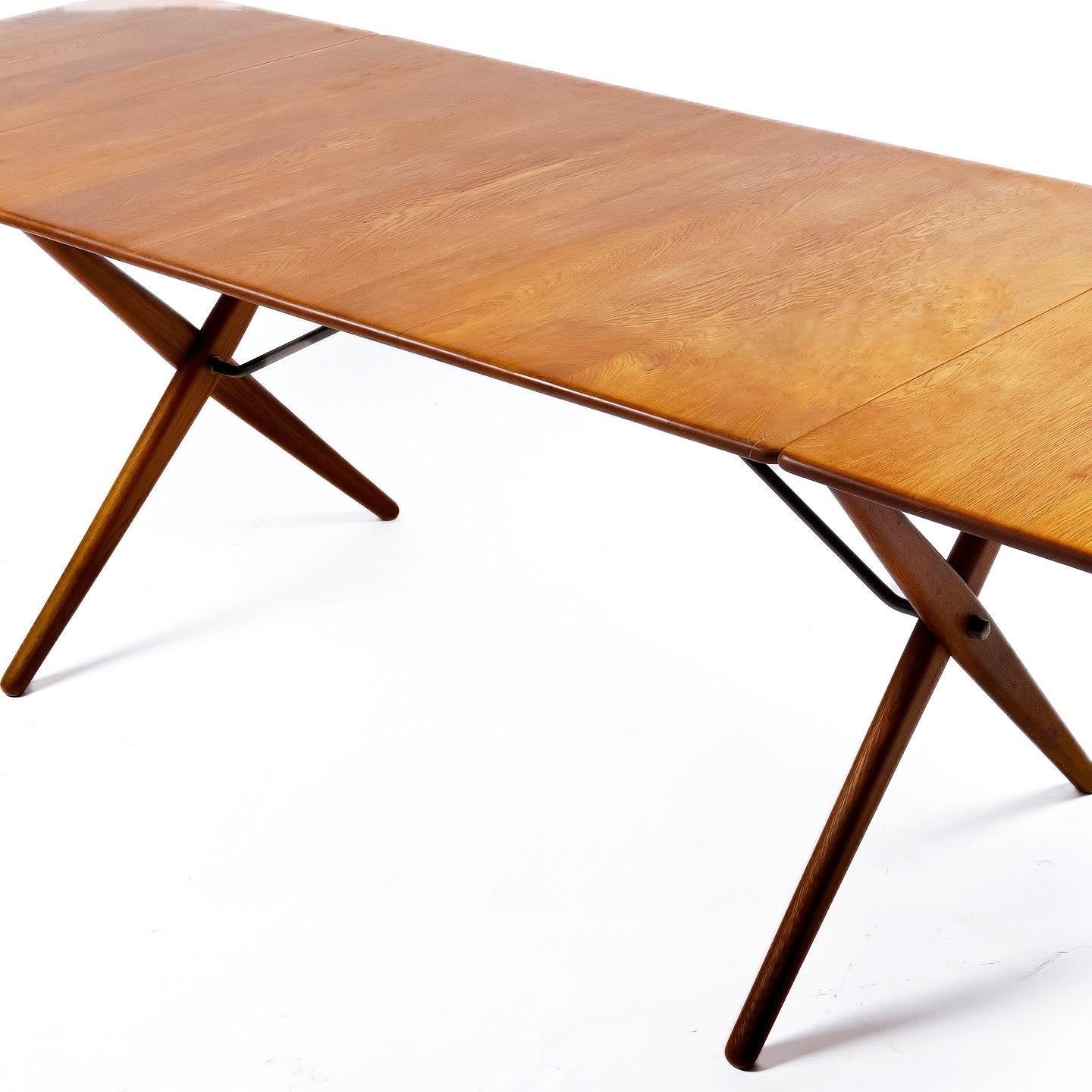 Solid teak top, oak legs and beautifully patinated brass supports. Model 309 dining table by Hans Wegner, made by Andreas Tuck. Denmark 1950s. Scarce model. Beautiful condition gently restored with signs of use. 
Drop-leaf design measures 50”l with