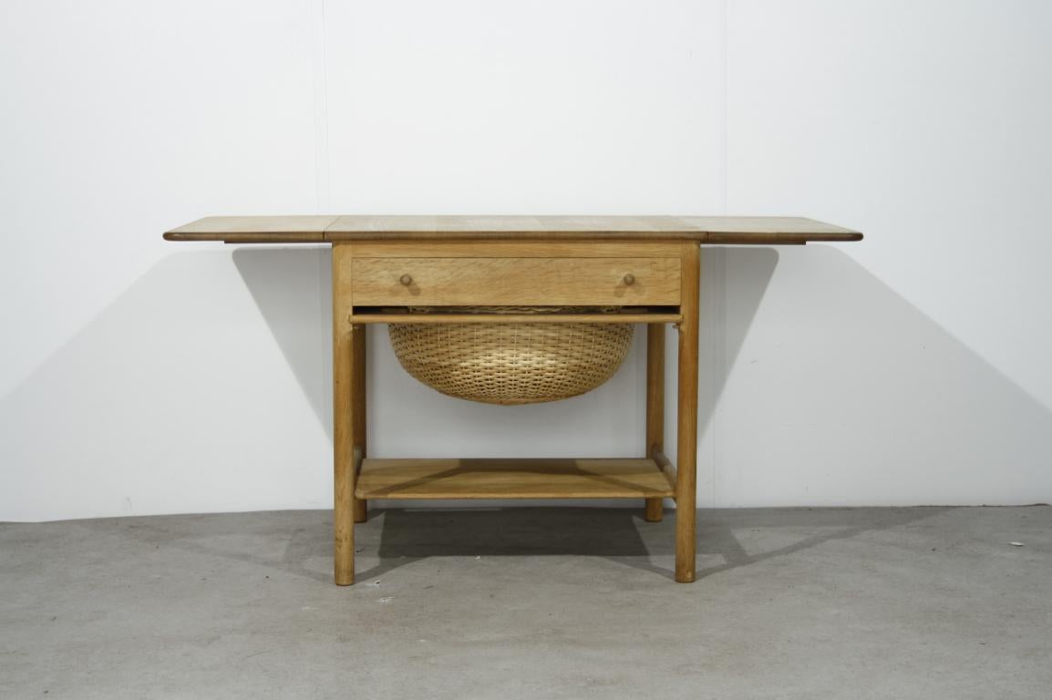 Hans J. Wegner “AT33 / PP33” sewing table for PP Mobler, Denmark, 1953

Oak sewing table with two extensions leaves, a drawer and a rattan basket.
In good condition

Measures Depth: 58 cm
Length 68 cm; extended 119 cm
Height 61 cm.