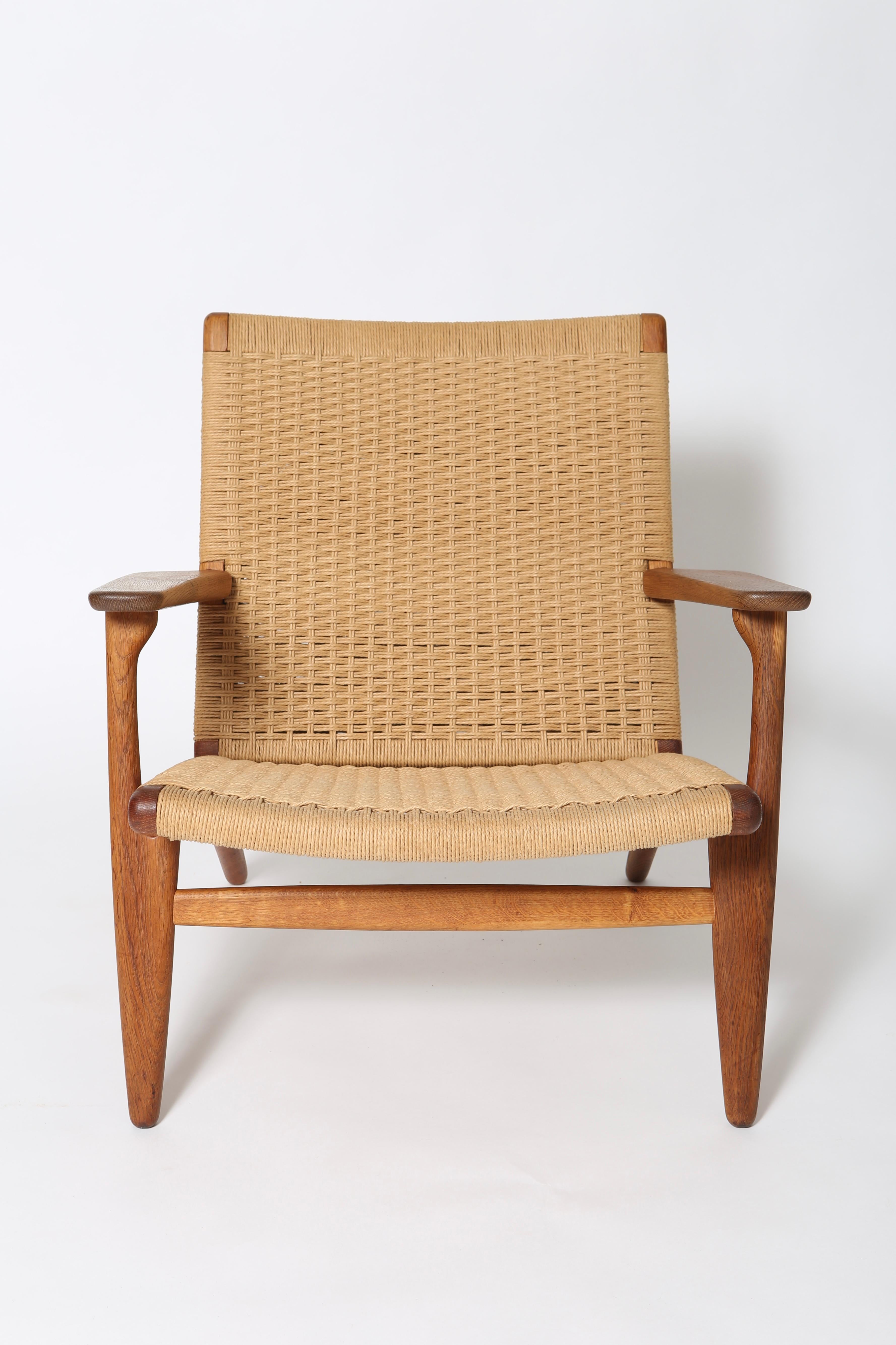 Iconic CH25 easy chair in oak by Hans J. Wegner. Early example, dates to the mid 1950s. Papercord intact and free from stains or abrasion. Frame shows nice age-appropriate patina. In excellent condition, this chair will be a family heirloom as it’s