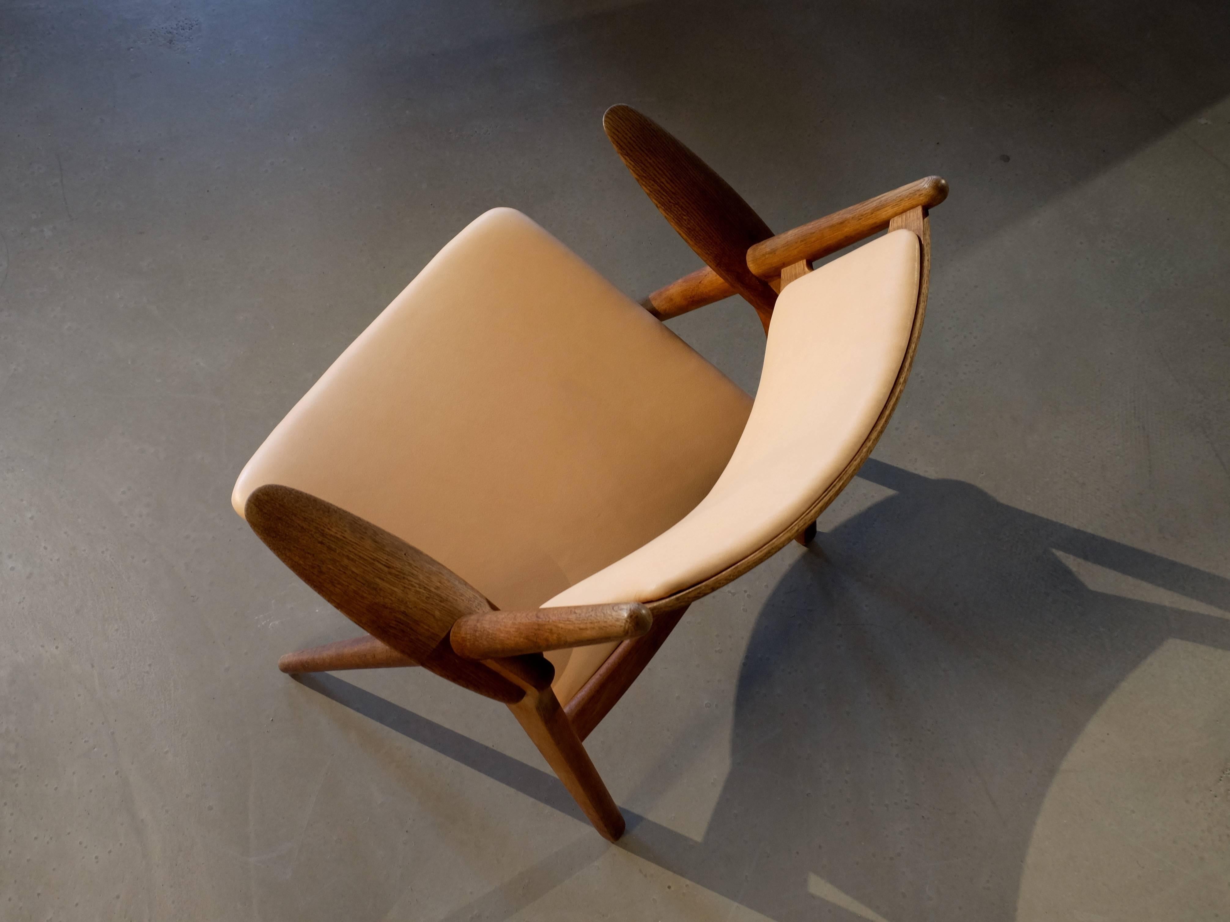 CH-28 sawbuck lounge chair designed by Hans J. Wegner for Carl Hansen & Sons, 1950s.

- New natural leather. 
- Teak and oak frame. 
- Global front door shipping USD 499.

         