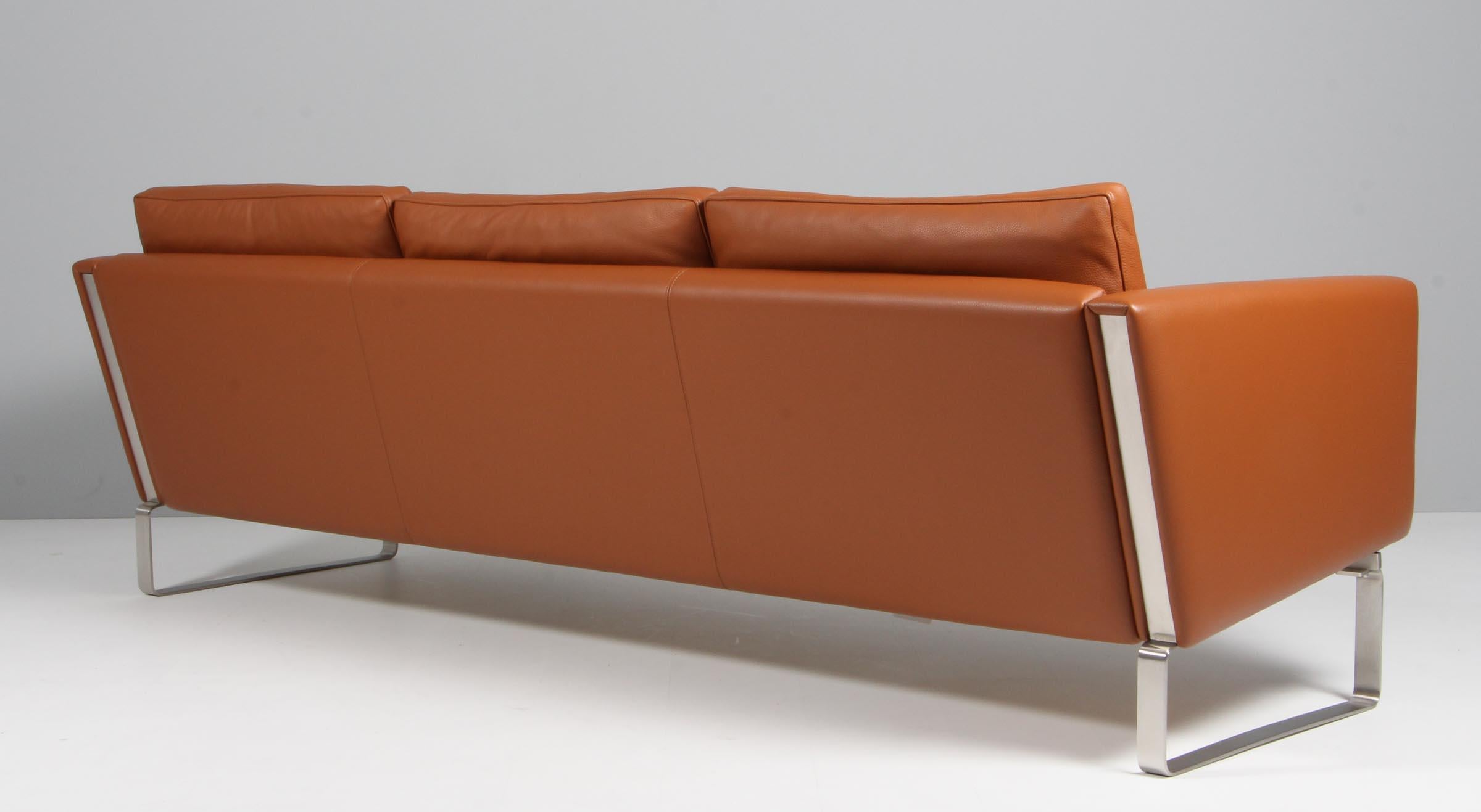 Hans J. Wegner three seat sofa with cognac leather frame and base of stainless steel. 

Model CH103, made by Carl Hansen.