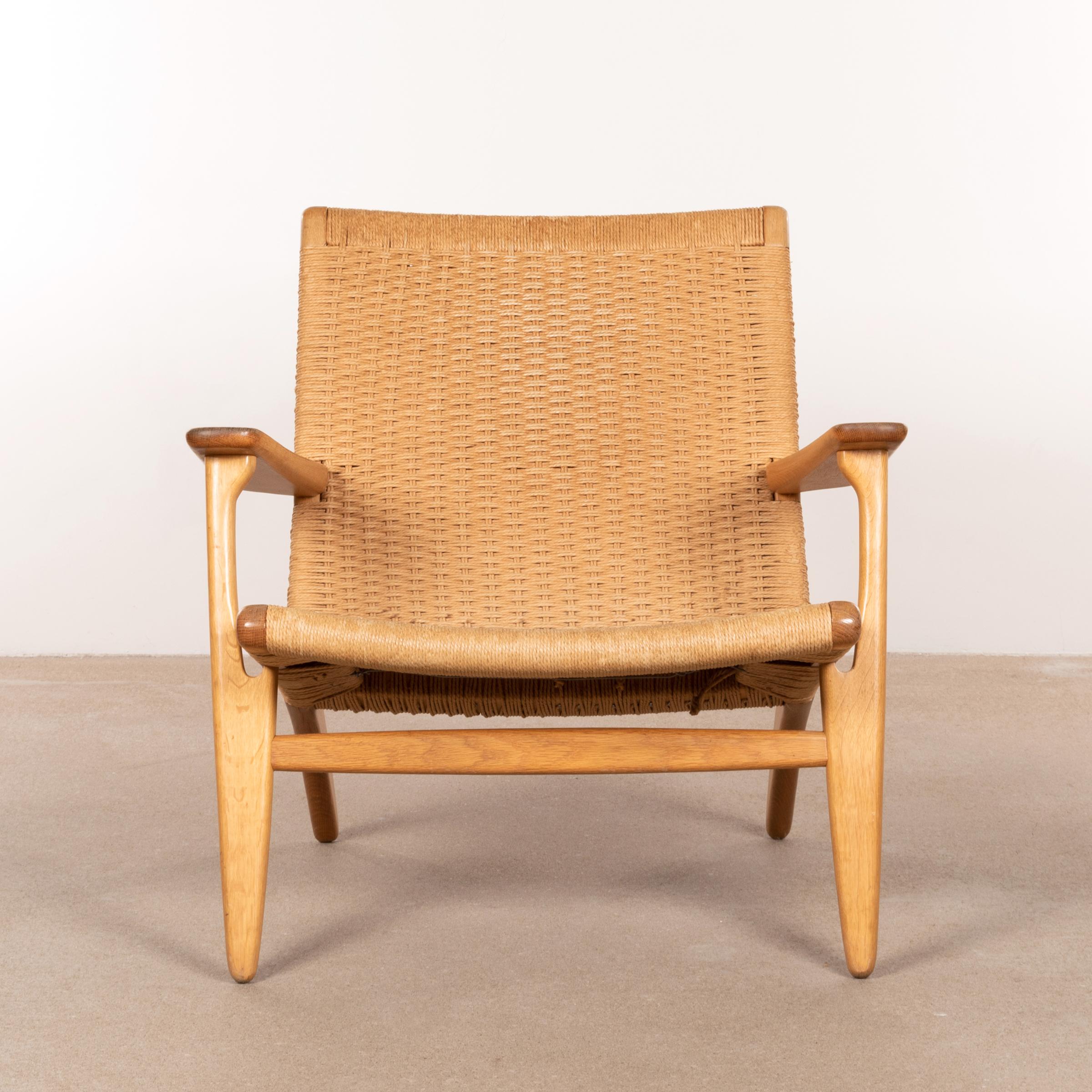 Hans J. Wegner CH25 lounge chair designed in 1950 and manufactured by Carl Hansen & Søn, Denmark. Very beautifully detailed and balanced design with natural look. Oak frame with paper cord in very good vintage condition with normal traces of use.