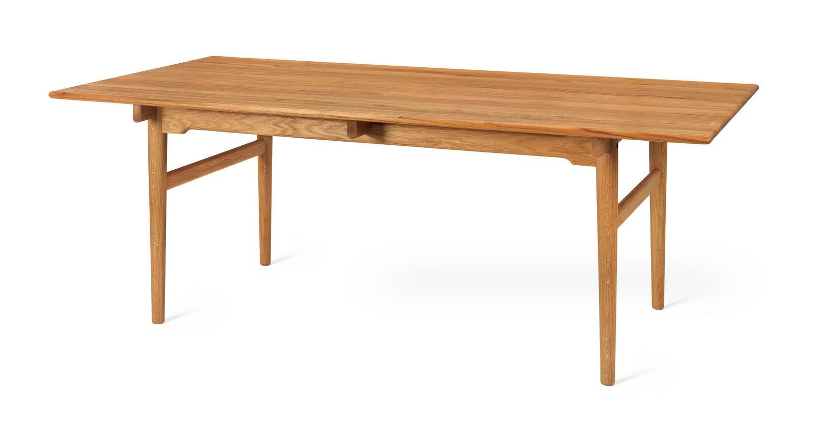 La table à manger CH327 pour 6 personnes de Hans J. Wegner, datant de 1962, présente un design inhabituel où le plateau semble presque flotter. Le plateau de la table est en bois massif avec des bords adoucis et des pieds arrondis qui se